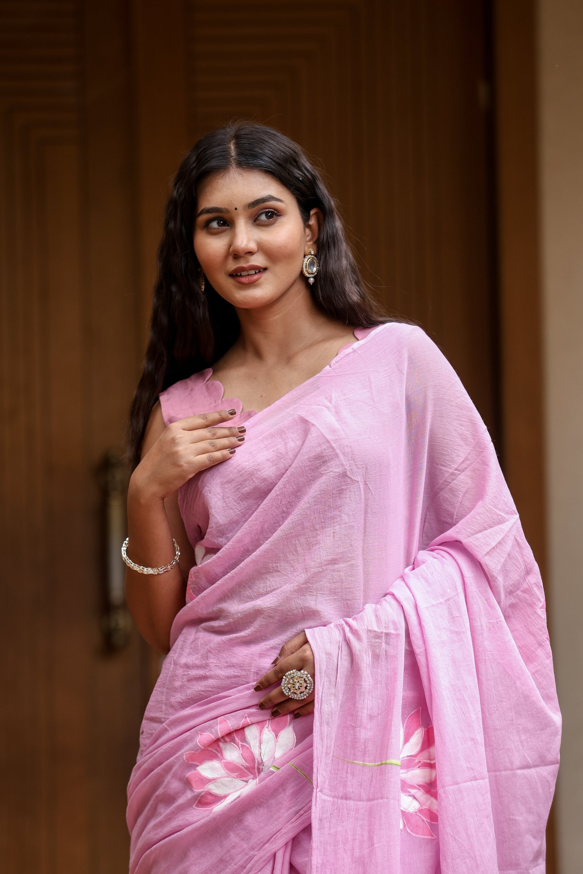 Beautiful woman wearing a lightweight summer saree for women in pastel pink with floral designs