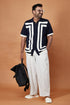 Stylish modern short sleeve polo shirt for men in navy with geometric design, paired with light trousers