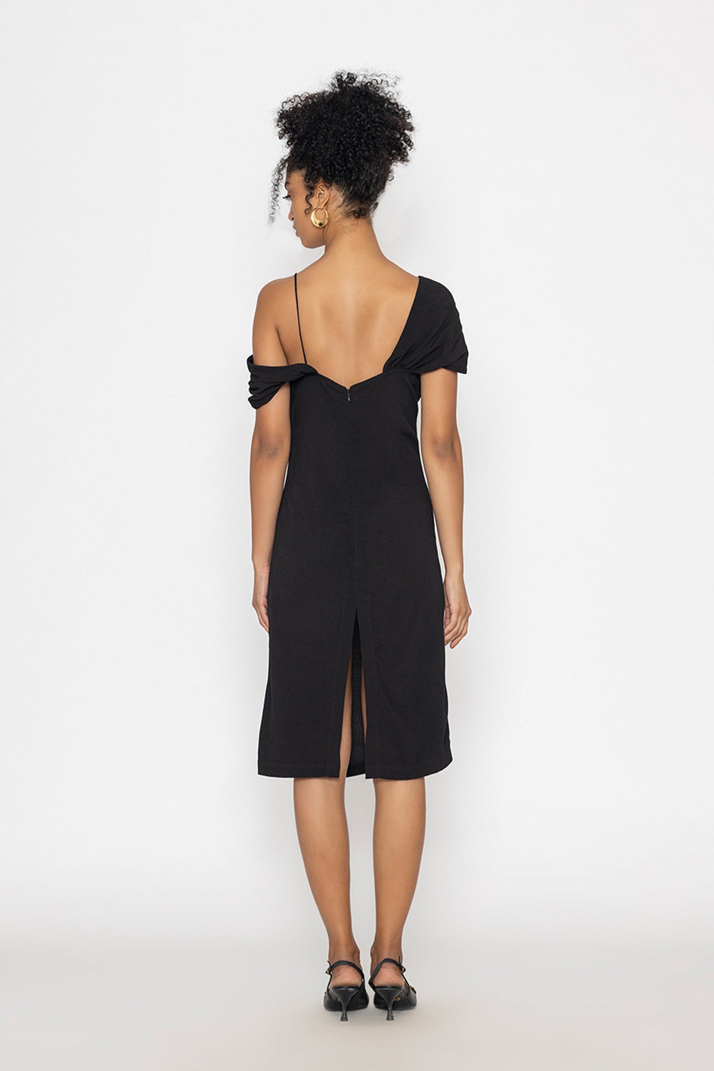 Back view of Stylera moonlit tide cocktail dress in black with off-shoulder and slit detail
