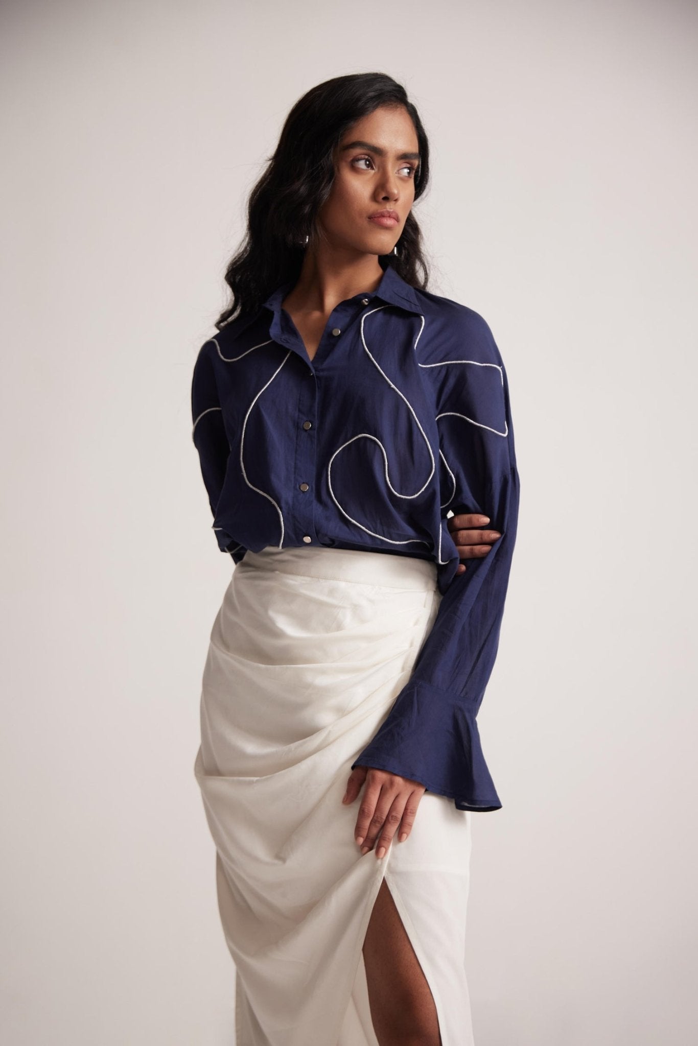 Woman wearing a navy blue oversized cotton shirt with white embroidery from Stylera