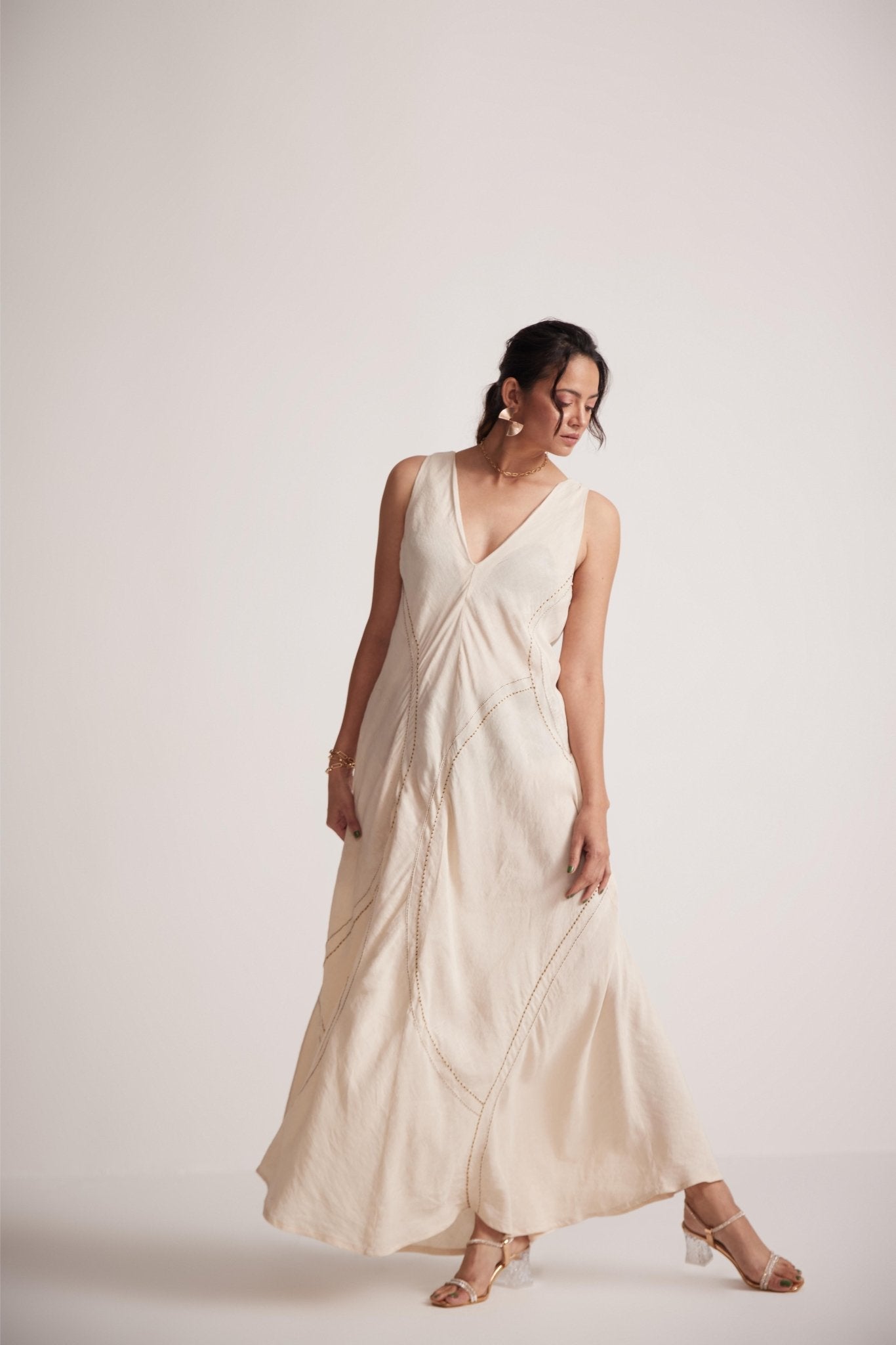 Woman wearing off-white event dress with embroidery detailing by Stylera posing gracefully