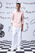 Stylera overlapping pocket shirt in light pink worn by male model with white pants