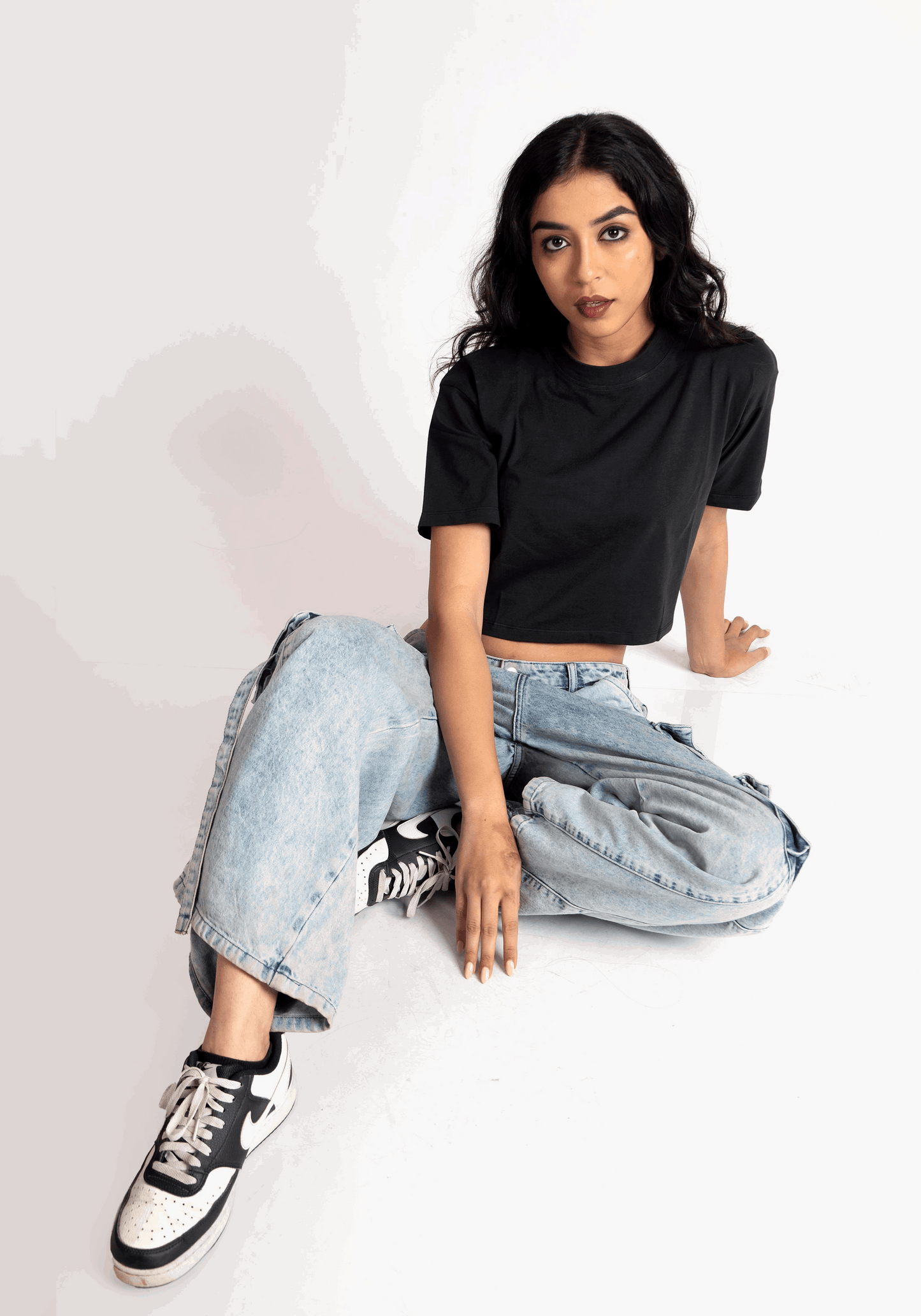 Stylera oversized cropped t-shirt for women in black worn with light blue jeans and sneakers