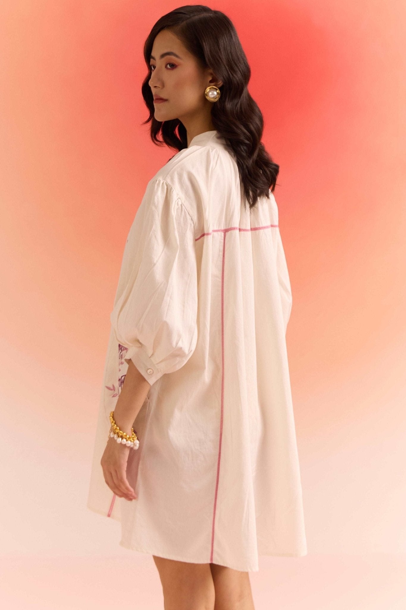Stylera oversized off white dress with puffed sleeves and pink seam detailing on model