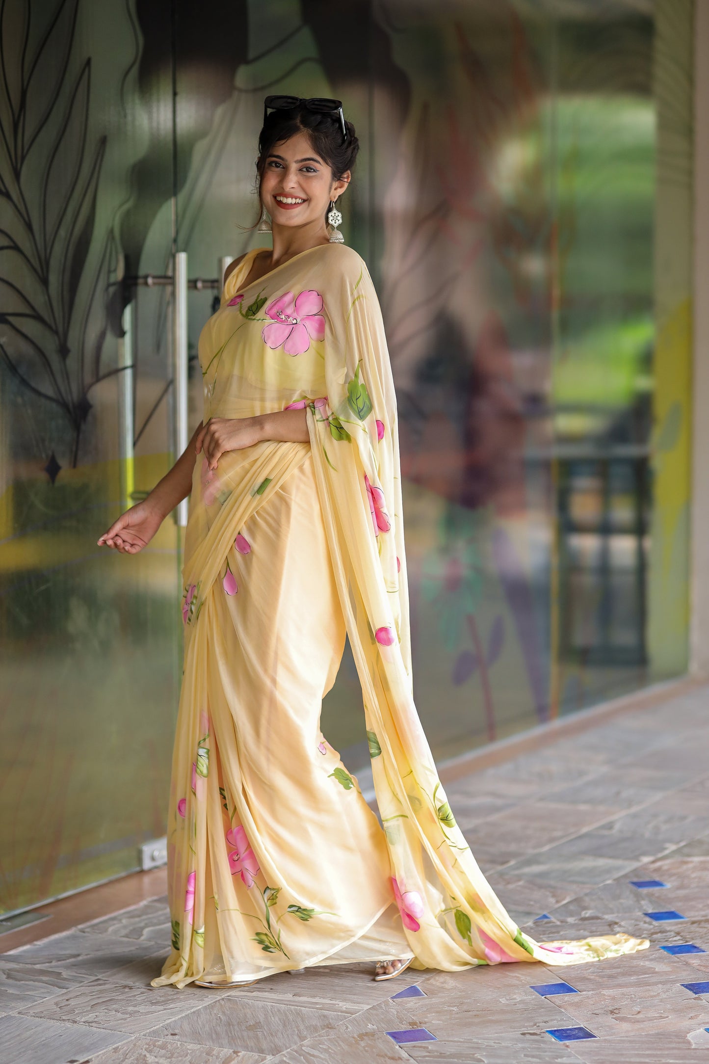 Pastel yellow floral saree for women with vibrant pink flower patterns draped elegantly