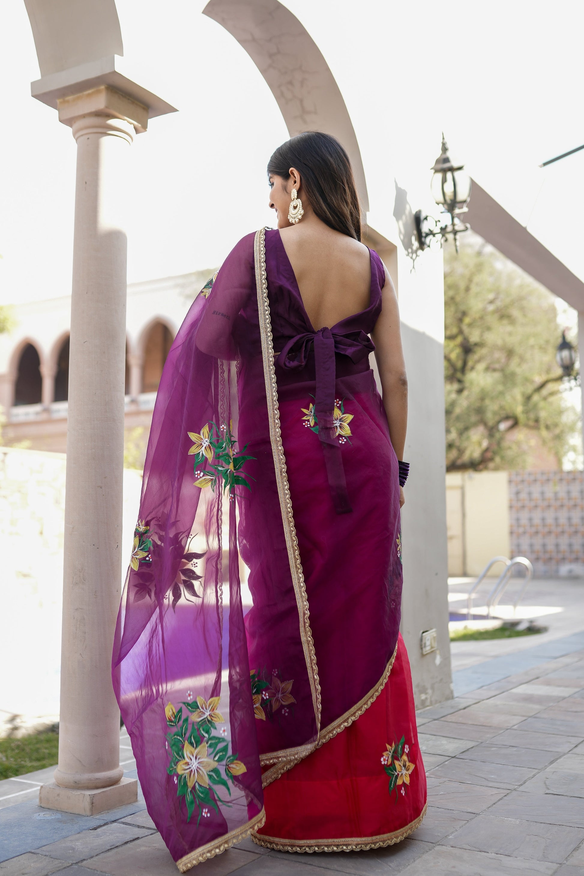 Elegant red and purple saree with handwork featuring intricate floral designs and a stylish back bow