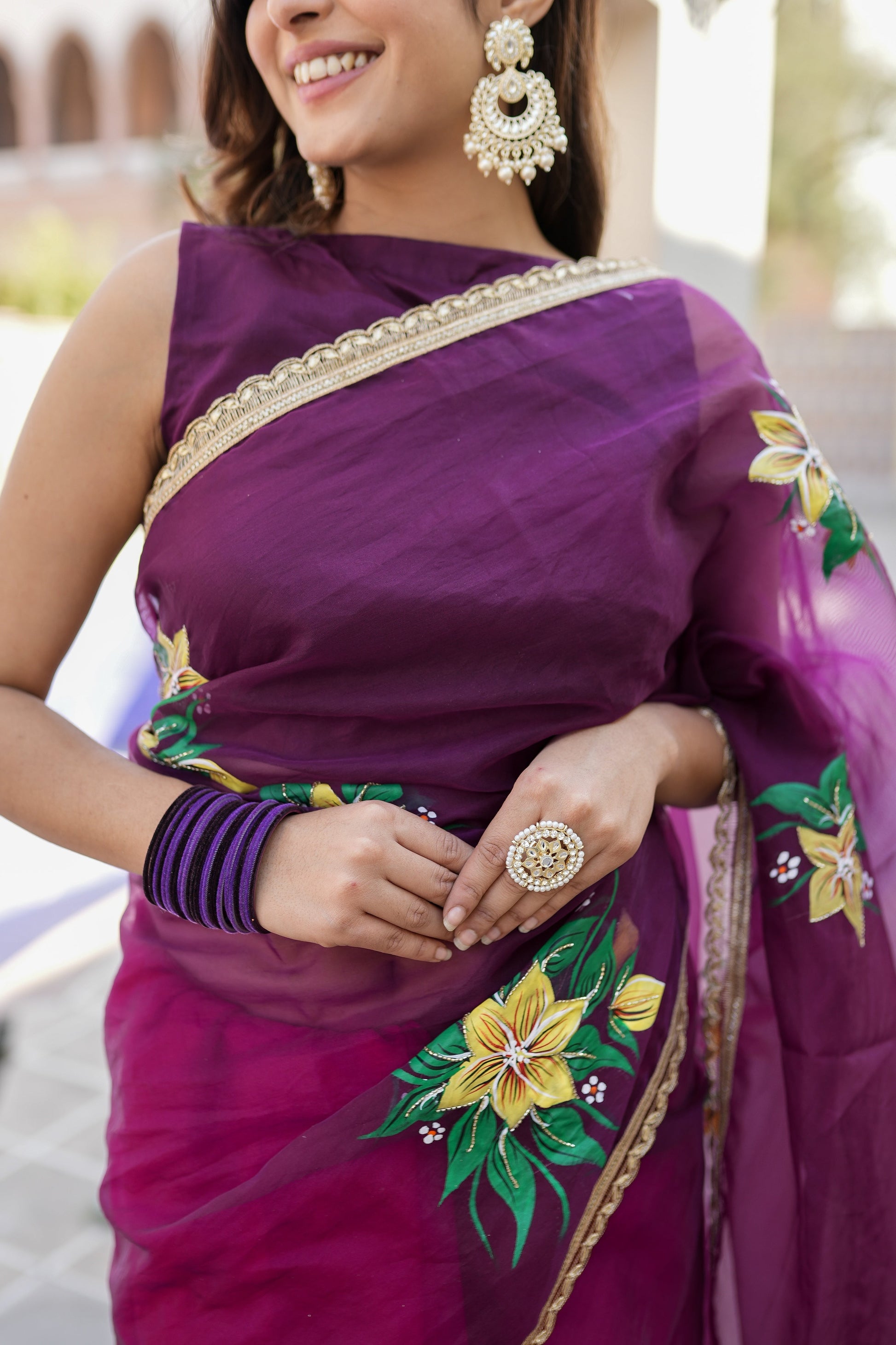Elegant red and purple saree with handwork featuring floral designs and embellished borders