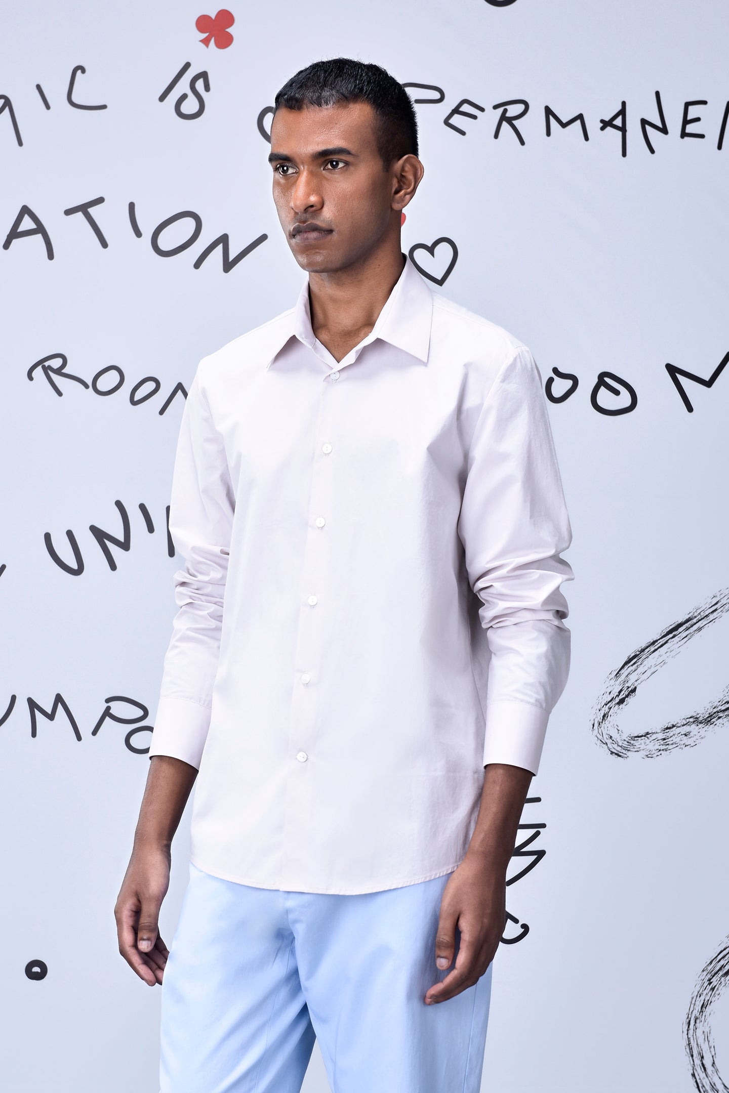 Stylera model wearing pale pink long sleeve button shirt with blue trousers regular fit men's shirt cotton