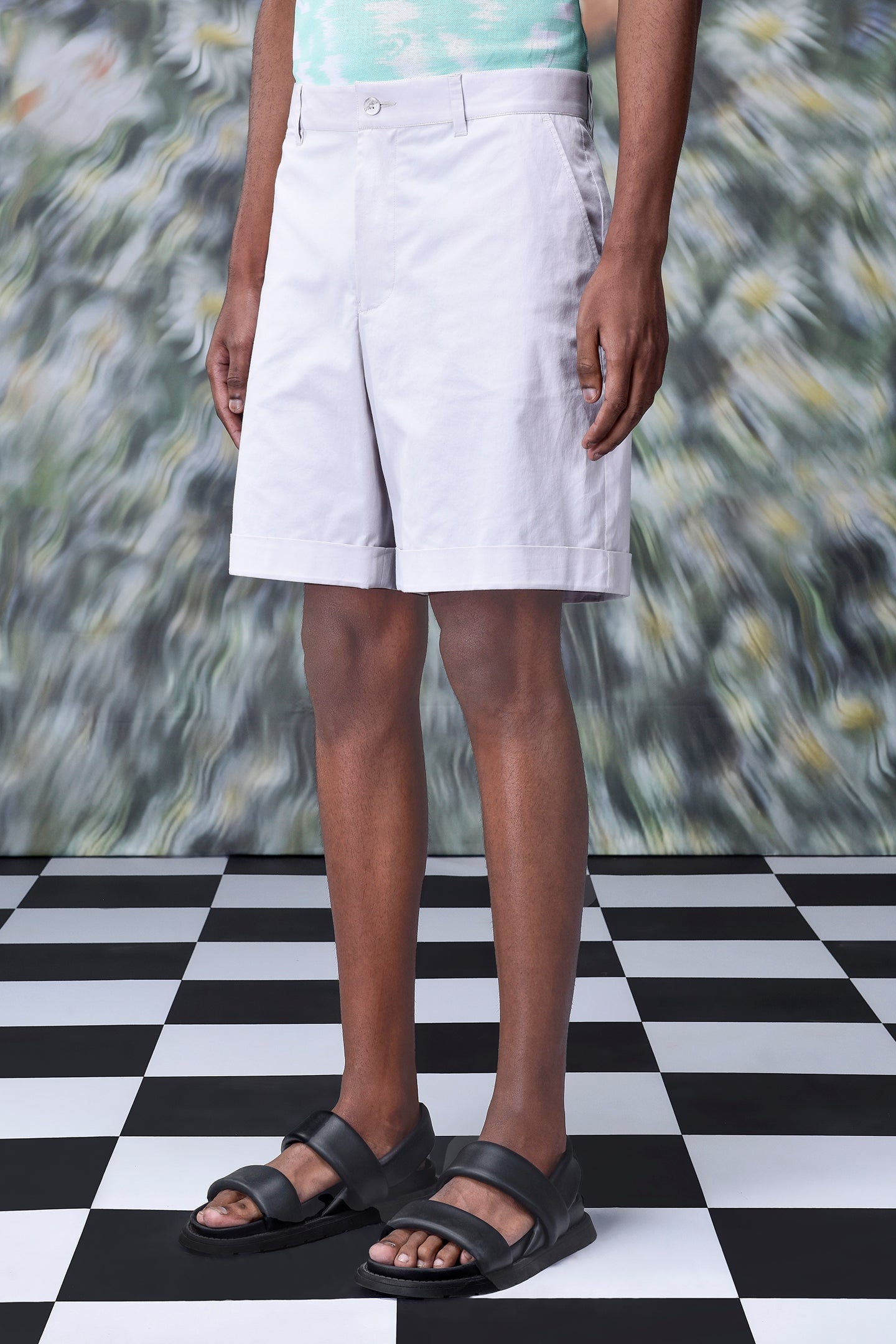 Stylera regular fit pearl grey shorts worn by model standing on checkered floor