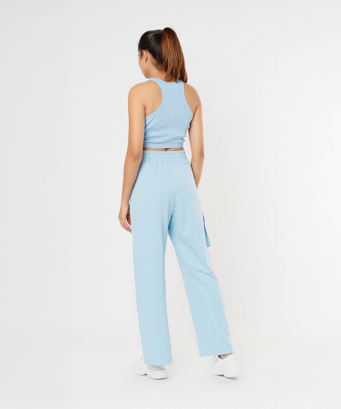 Back view of a model wearing stylish co ord sets for women in light blue, featuring a cropped tank and wide-leg pants.