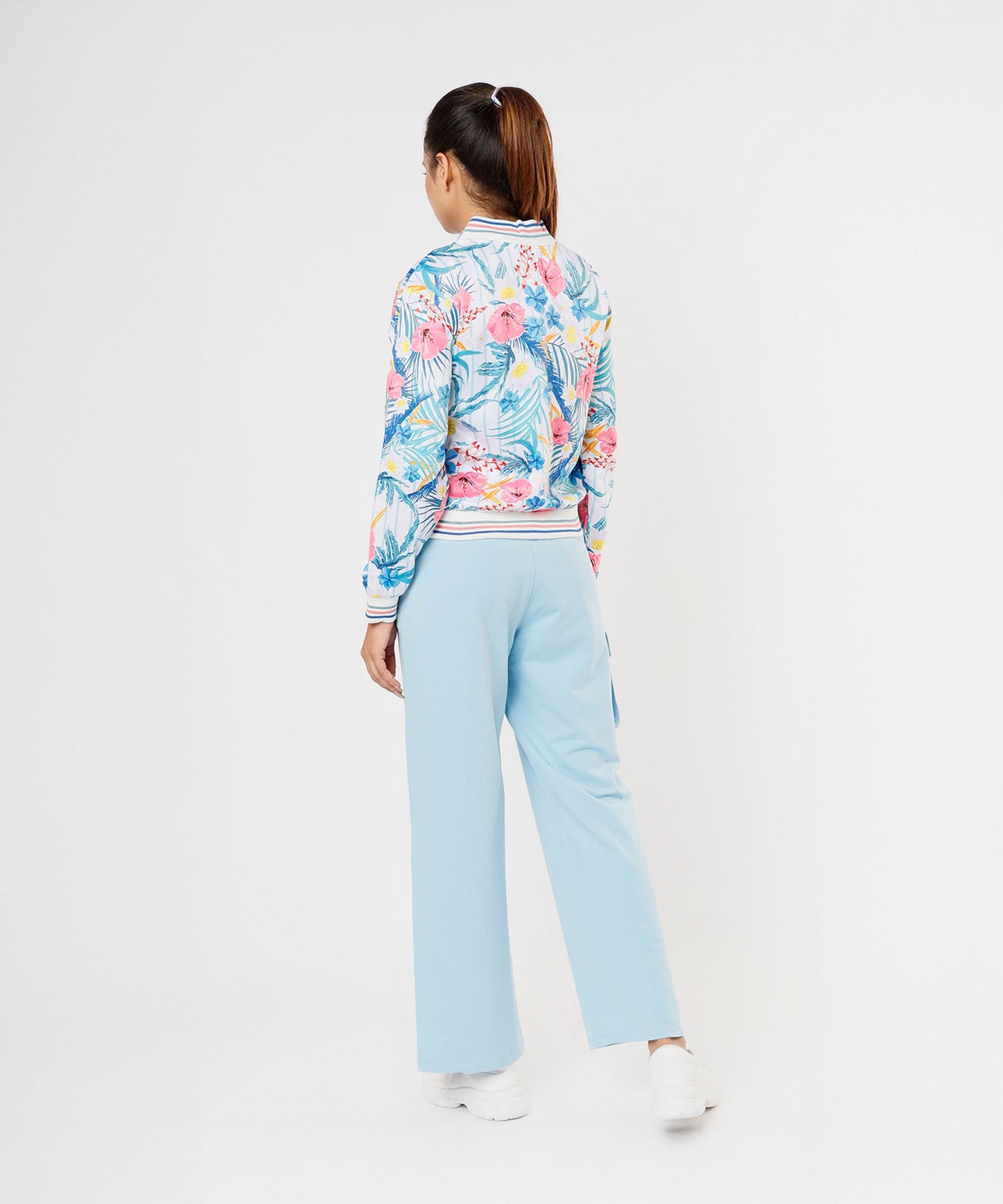 Back view of a woman wearing a colorful floral jacket and light blue pants from Stylera, stylish co ord sets for women