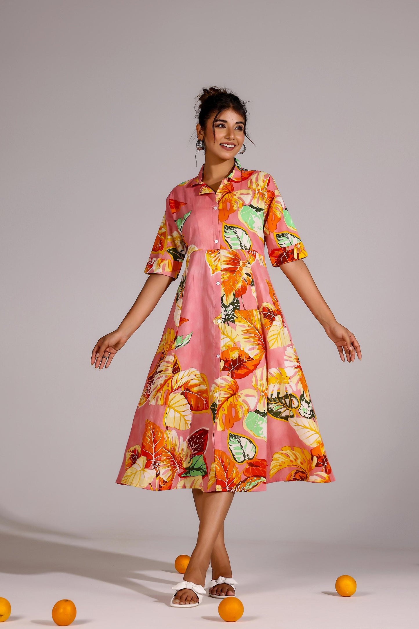Model wearing a vibrant summer pink cotton dress with floral patterns and a flared silhouette