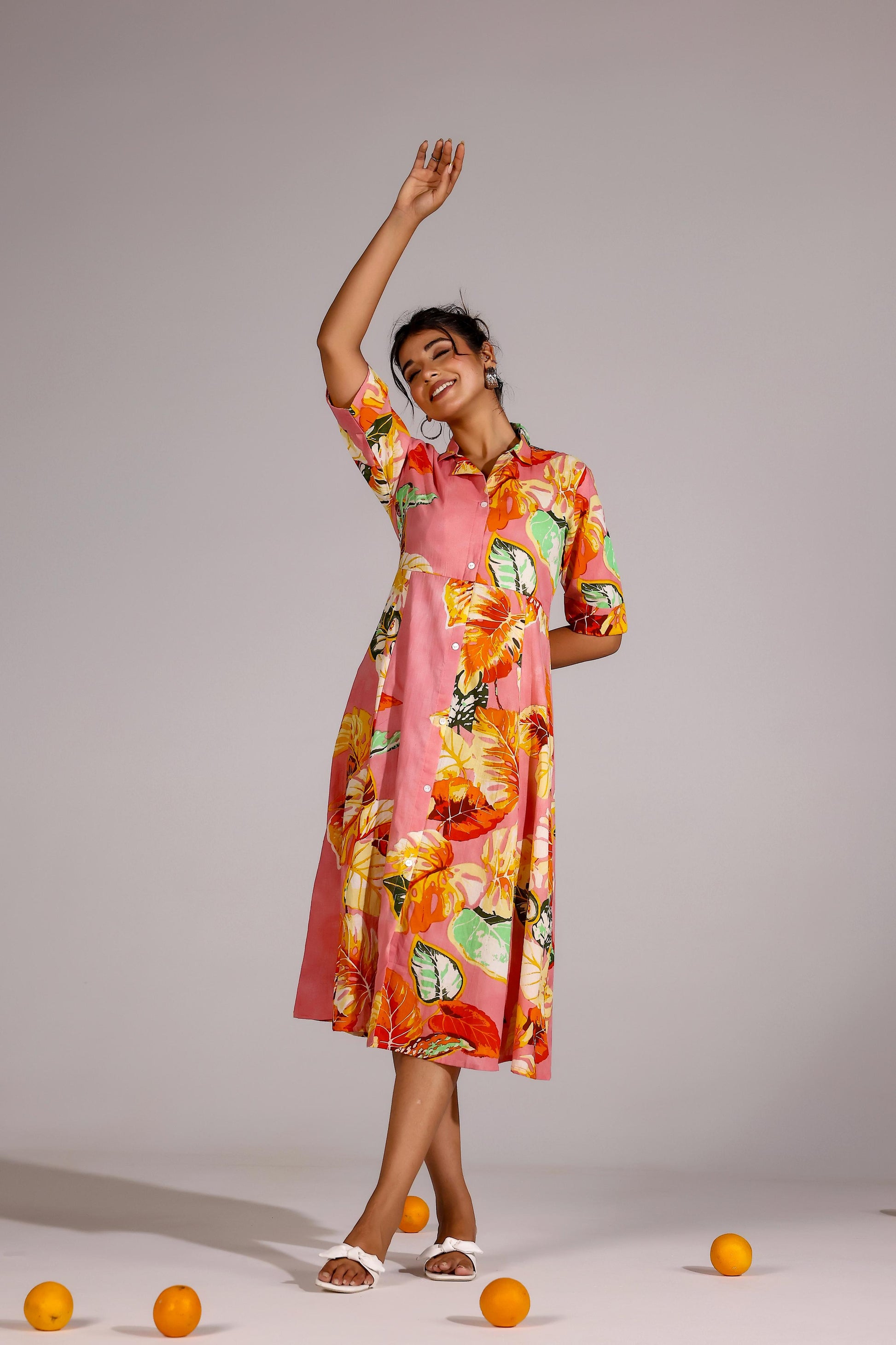 Model wearing a summer pink cotton dress with vibrant floral patterns, perfect for warm weather styling