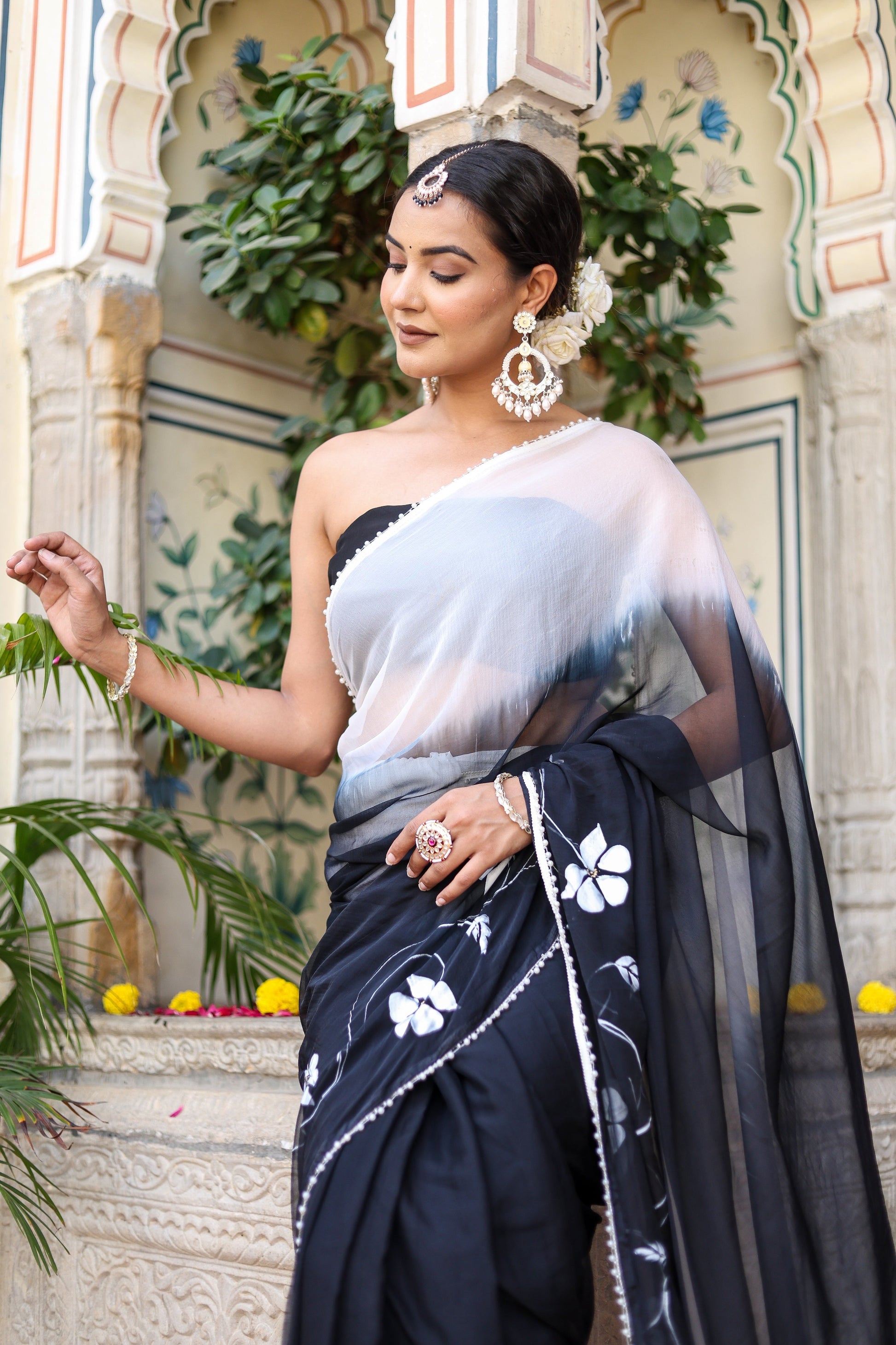 Trendy elegant party wear saree in black with floral embroidery, styled with matching accessories