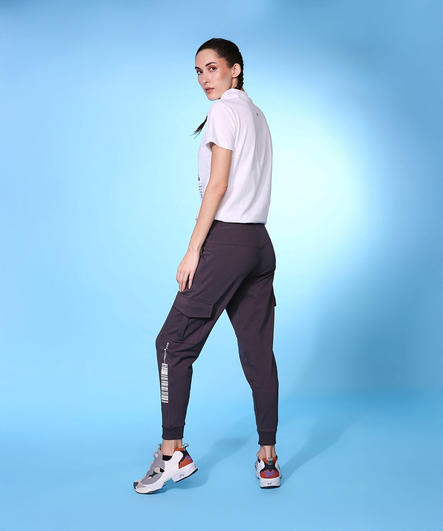Model wearing trendy fashion joggers with pockets paired with a white t-shirt against a blue background