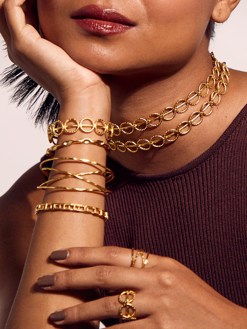 Stylera layered circular link gold necklace on model with matching bracelets and rings trendy gold accessories
