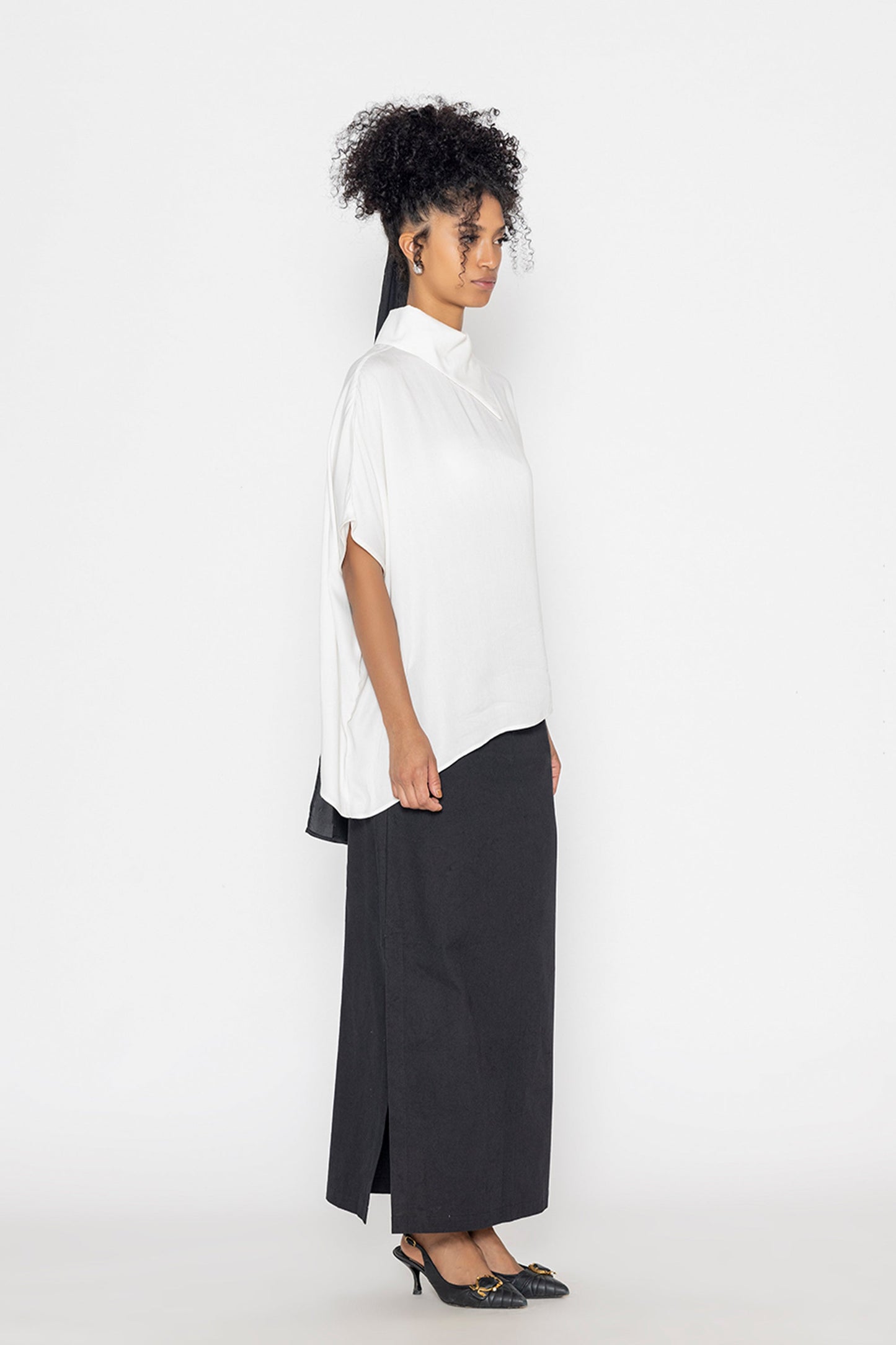 Stylera trendy minimalist women’s top in white with loose fit, paired with black skirt and heels