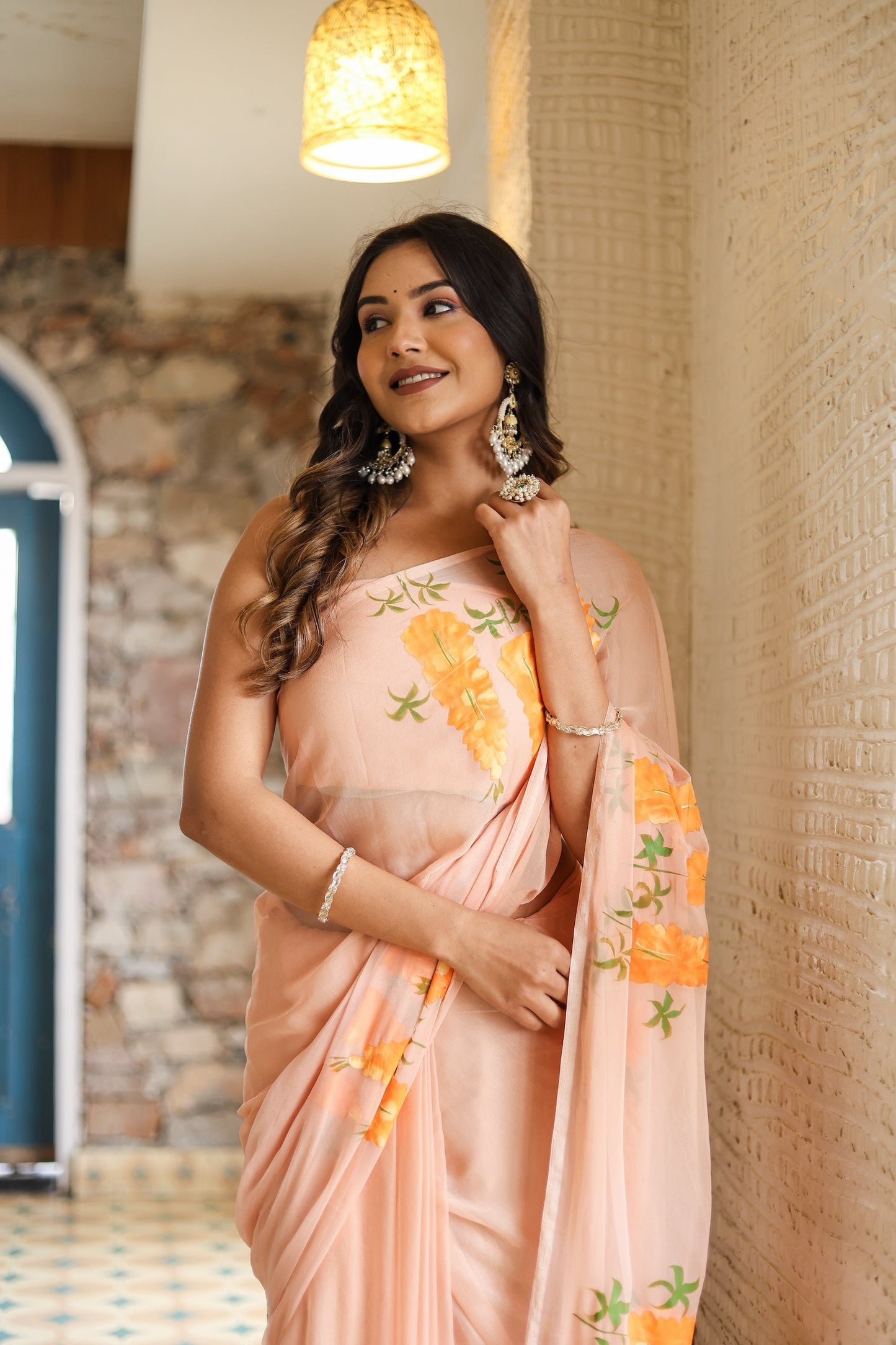 Stylish model wearing a trendy peach saree with floral design for special occasions