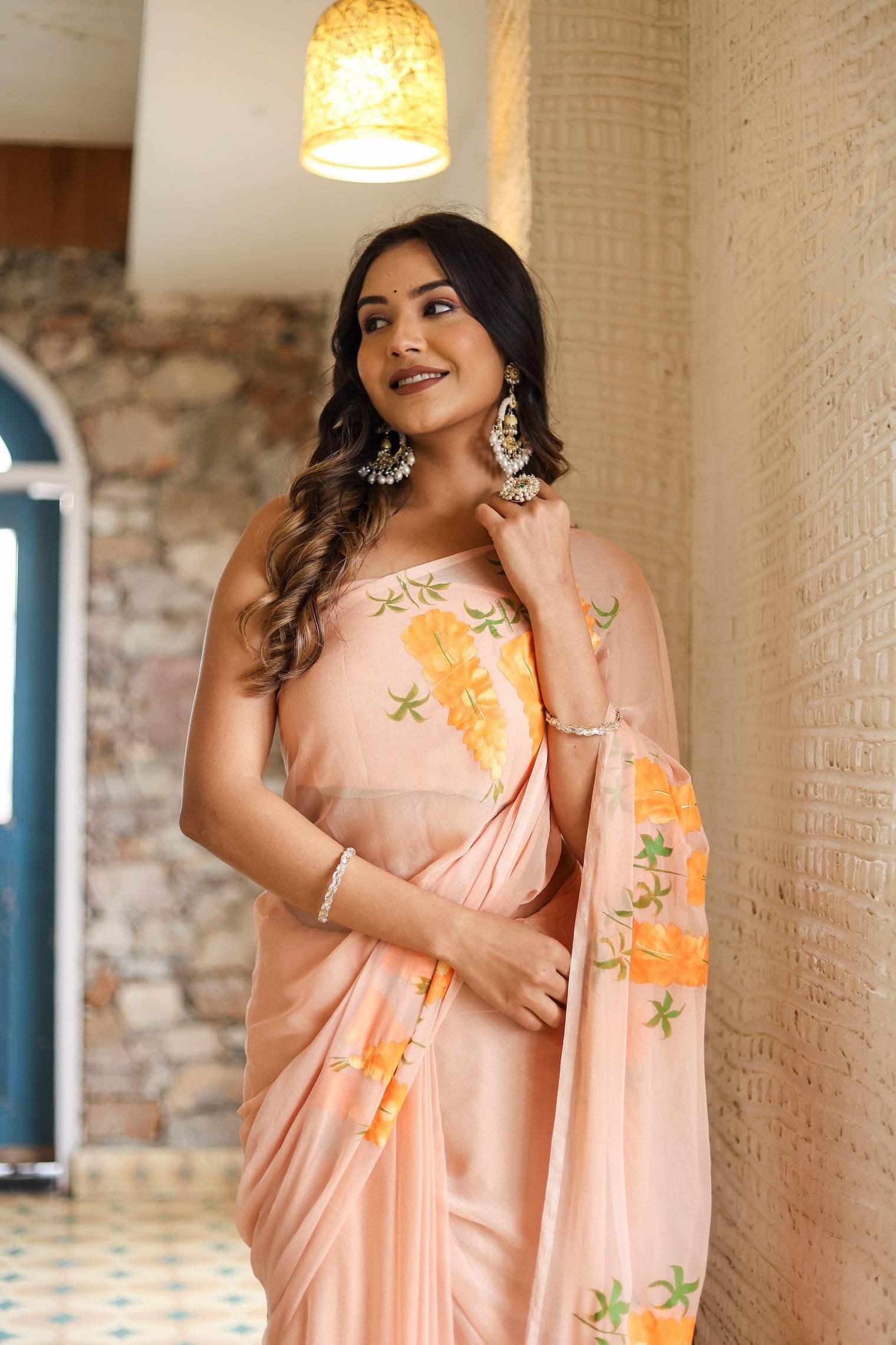 Stylish model wearing a trendy peach saree with floral design for special occasions