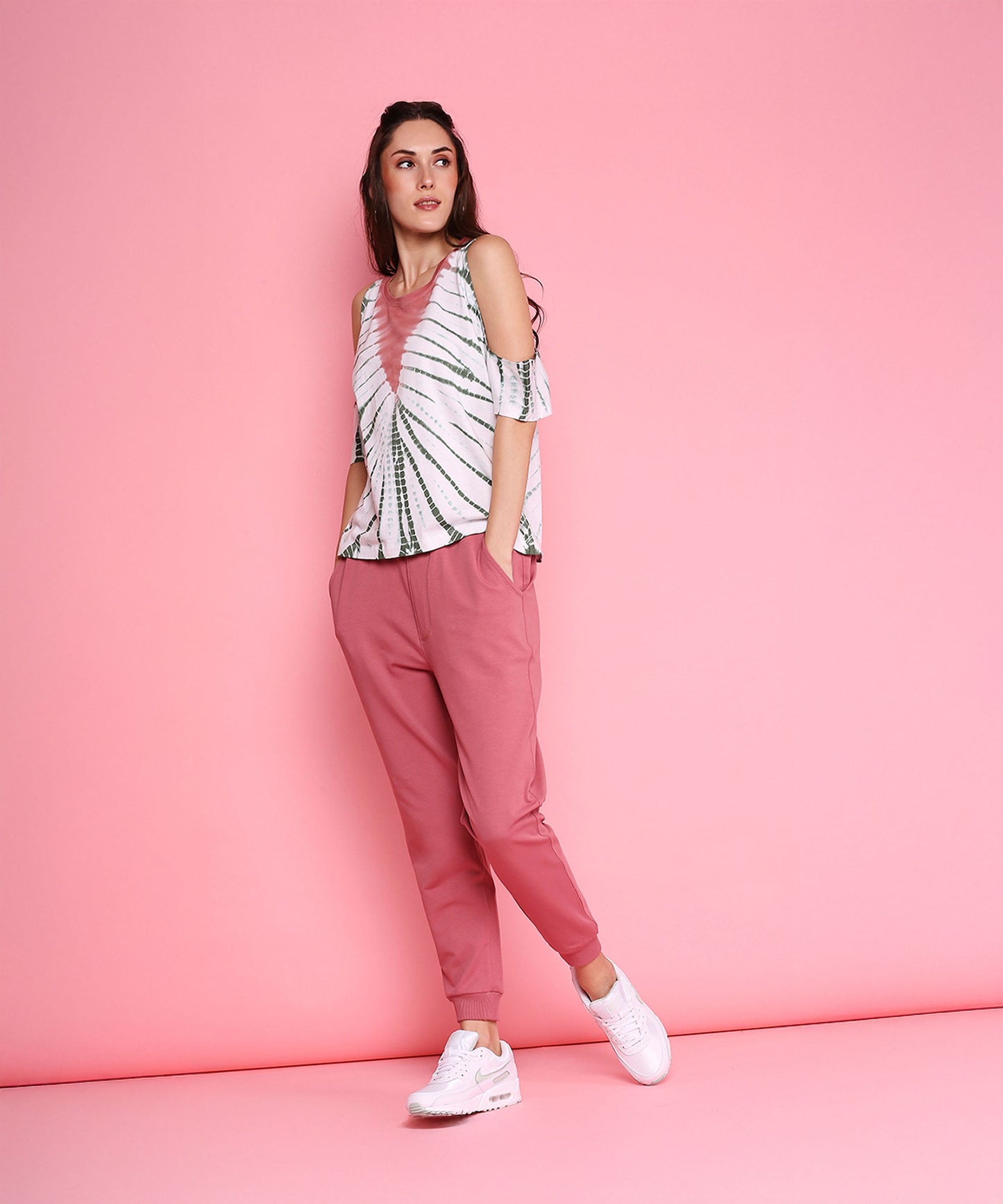 Model wearing trendy pink sweatpants paired with a stylish top against a pink backdrop