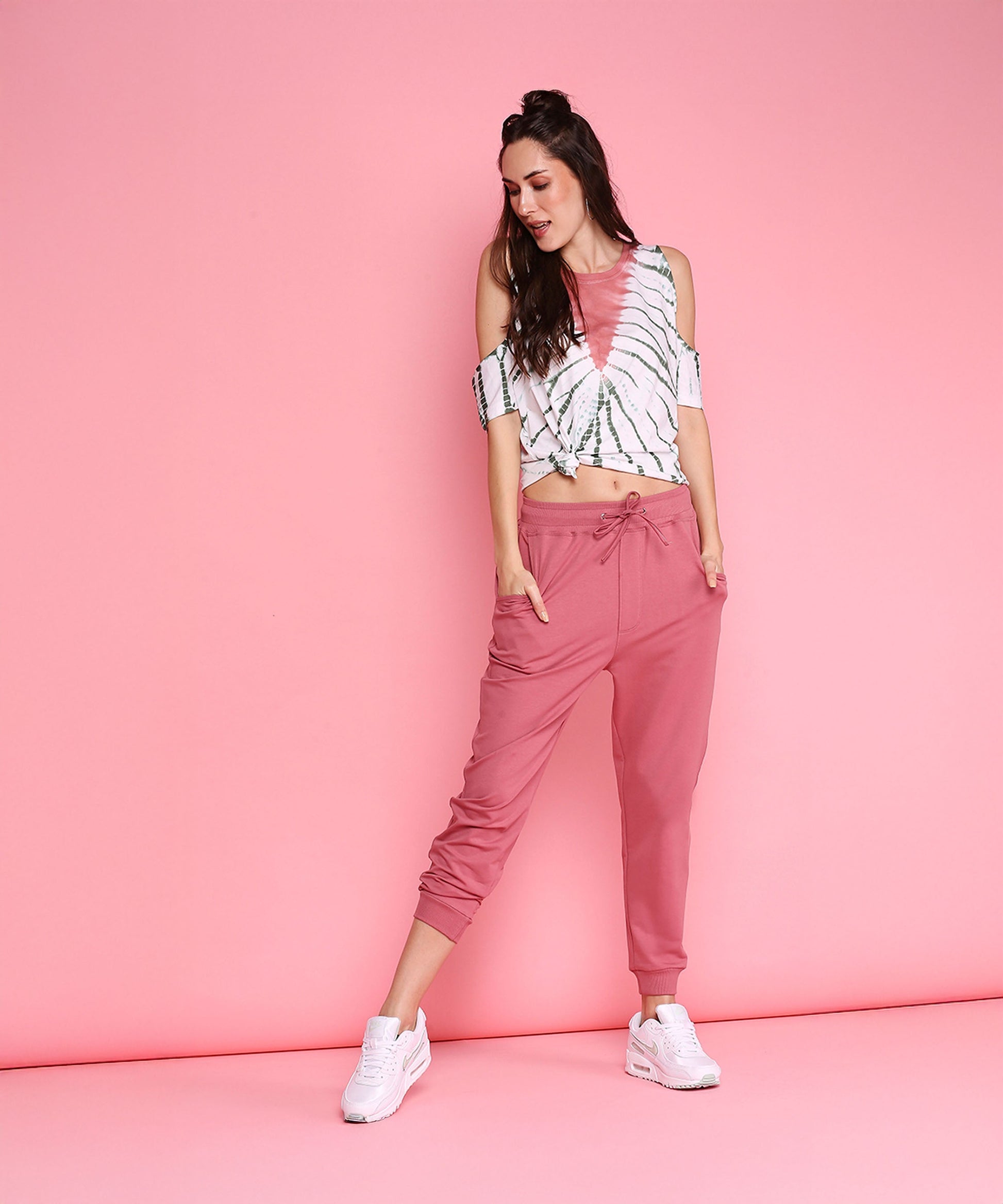 Trendy pink sweatpants with a relaxed fit, styled with a casual crop top and white sneakers