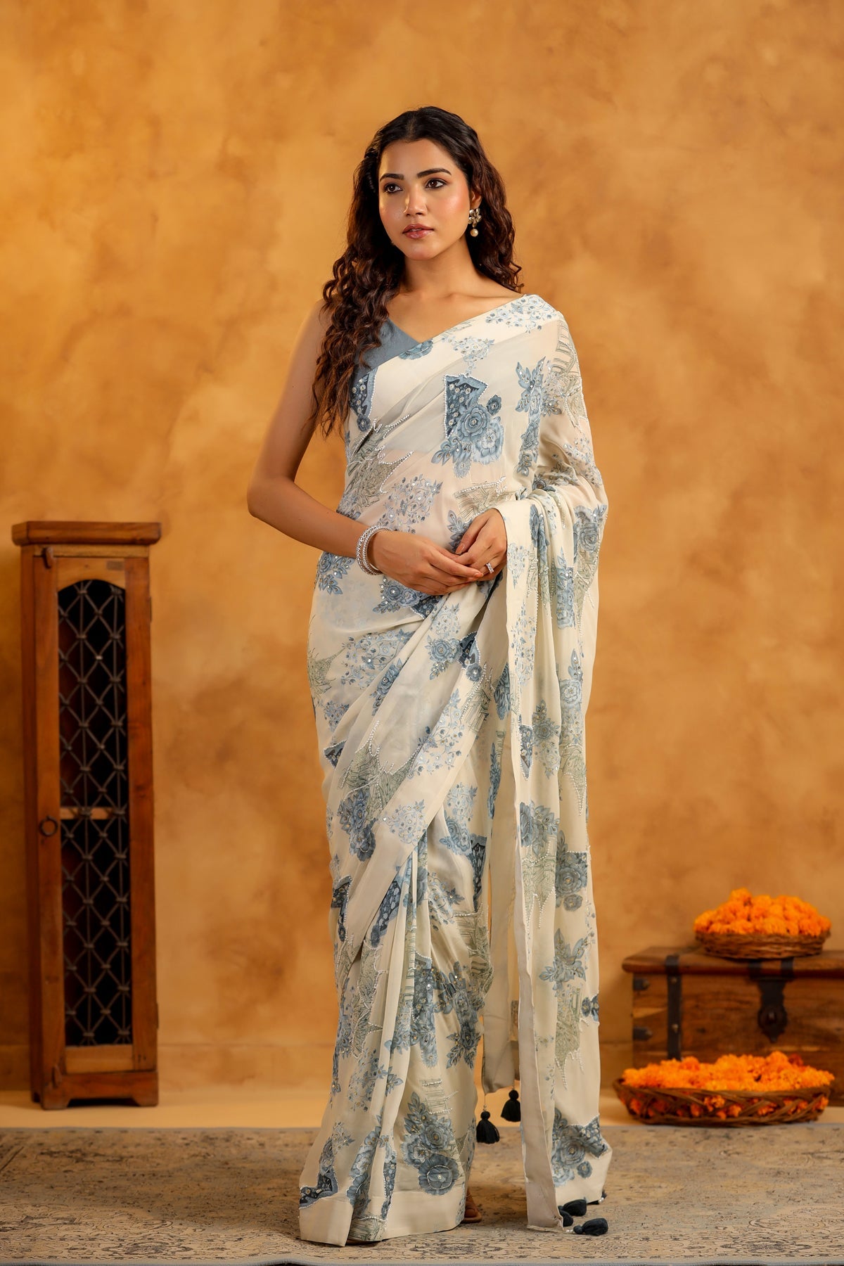 Model wearing Stylera white and blue floral trendy saree with blouse set featuring V neck blouse and tassel pallu