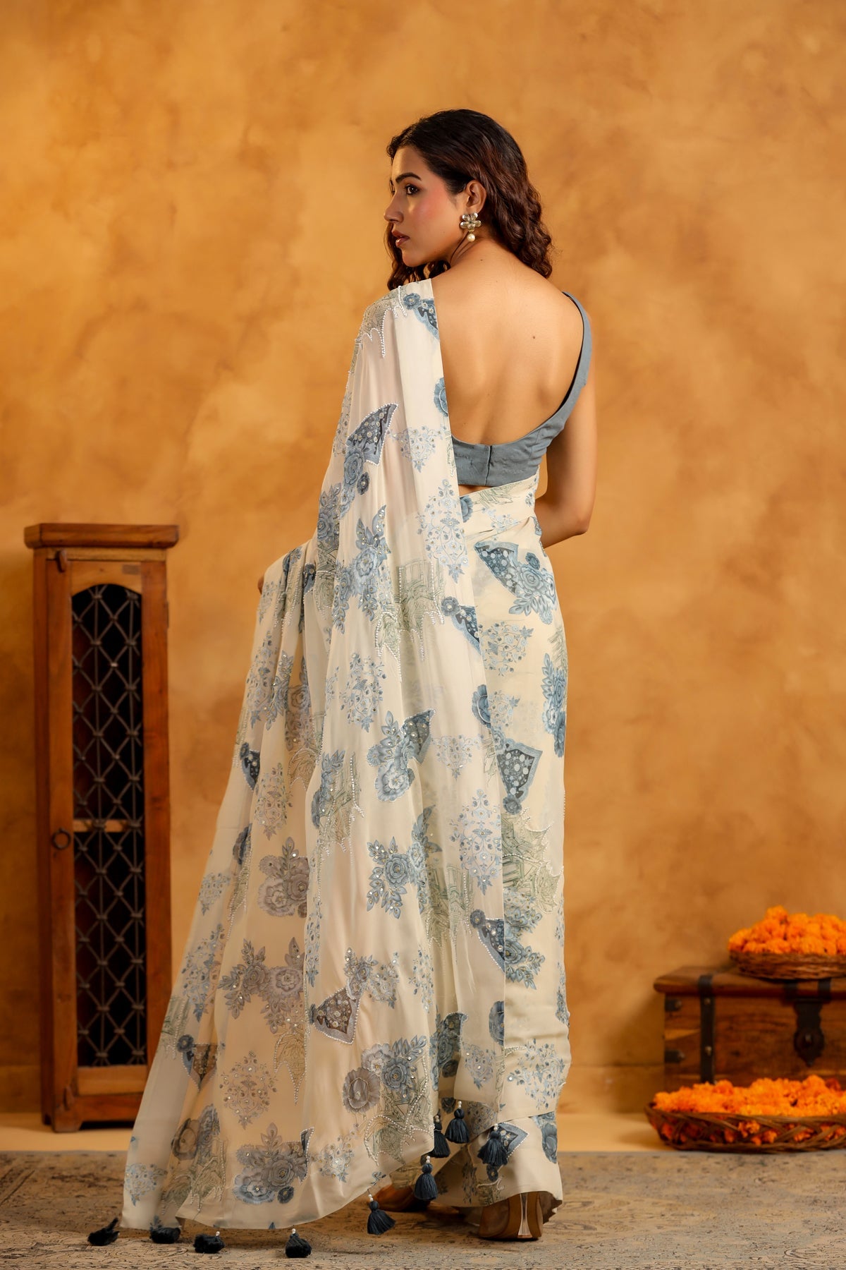 Stylera model wearing trendy saree with blouse set white chiffon saree with blue floral print and backless blouse