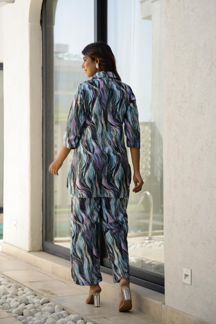 Woman wearing trendy satin pajamas set with a colorful abstract design, perfect for stylish loungewear