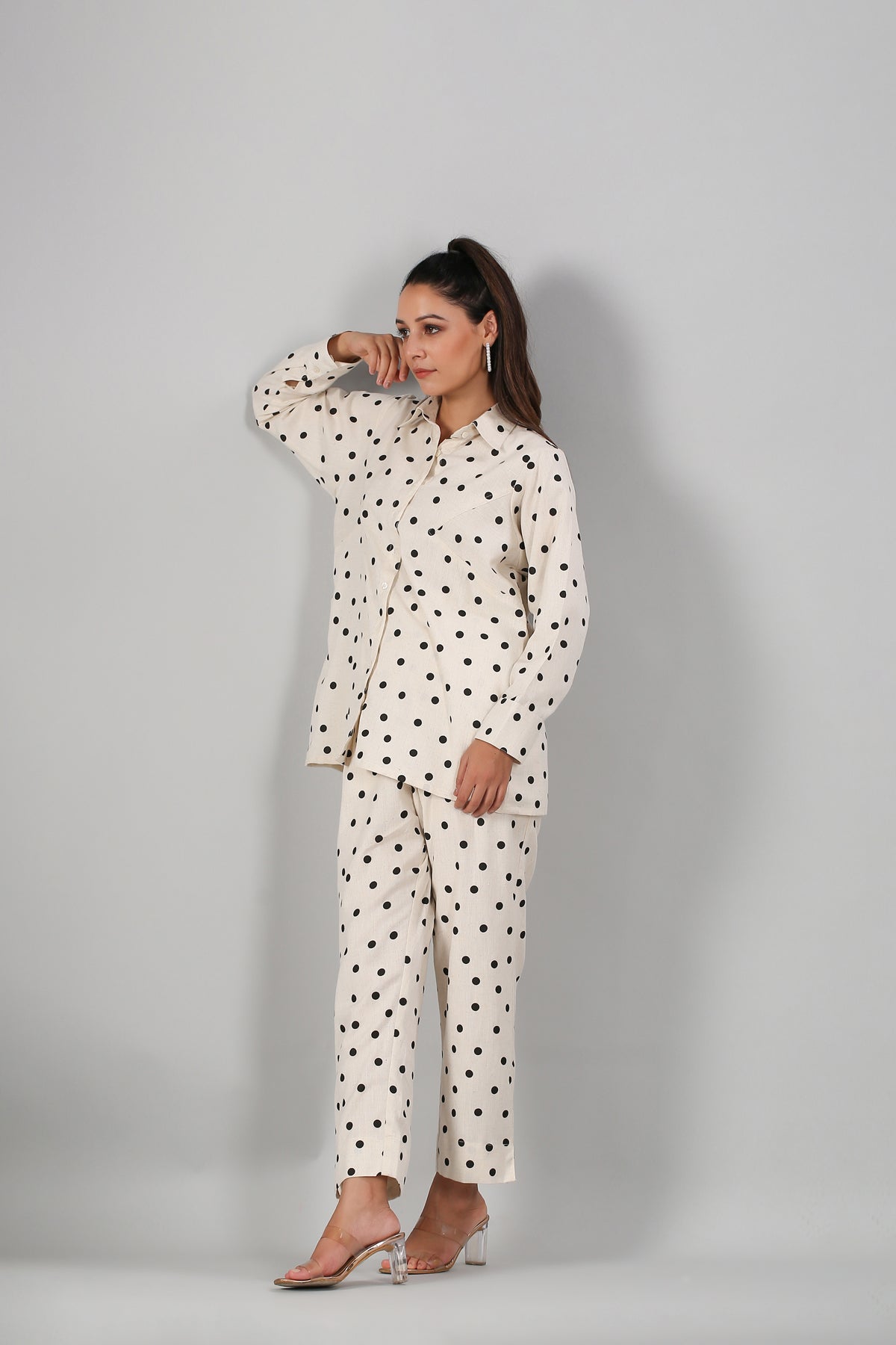 Stylera model wearing cream two piece outfit polka dots long sleeve button shirt and cropped pants
