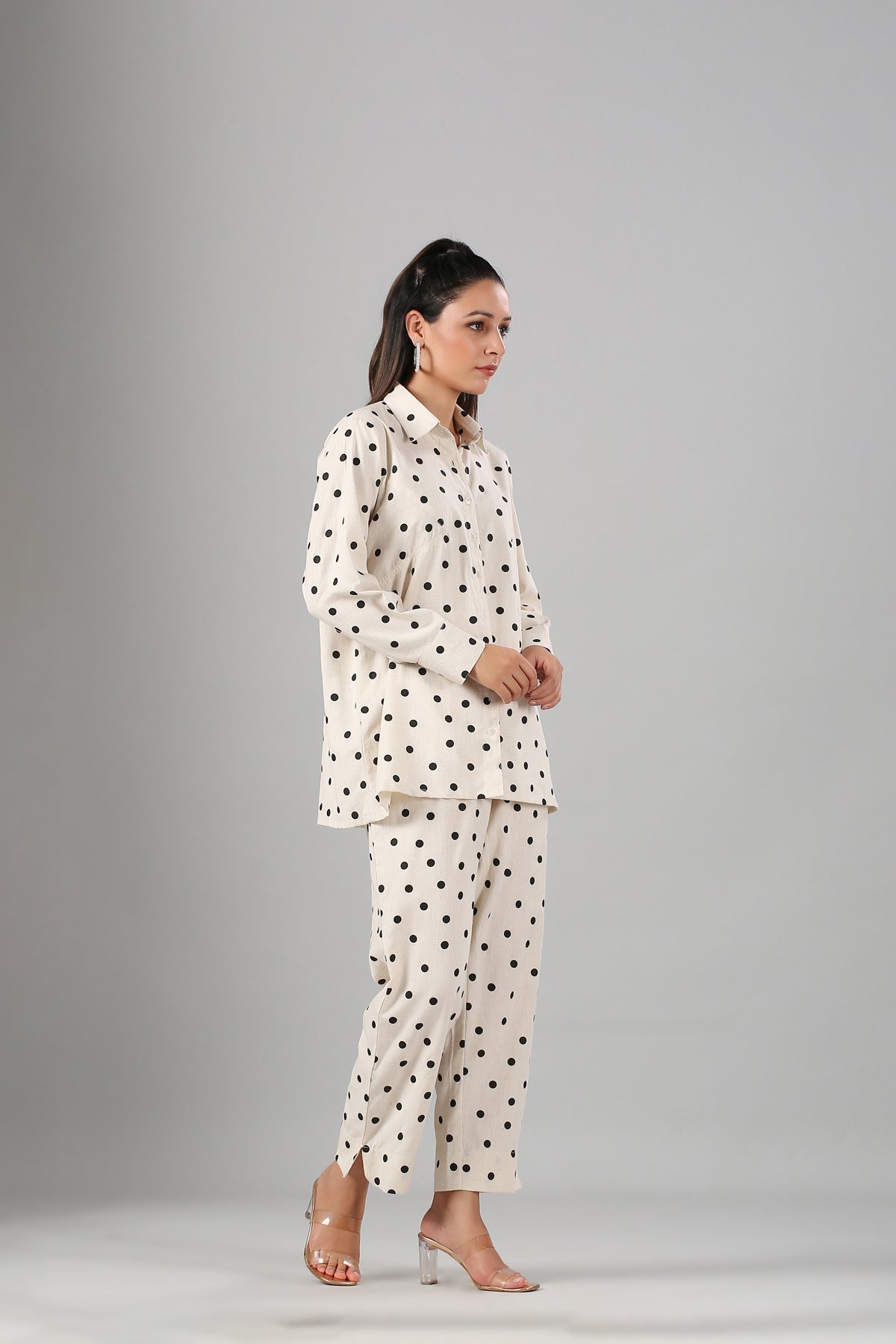 Model wearing Stylera beige two piece outfit polka dots long sleeve collared top and wide leg pants