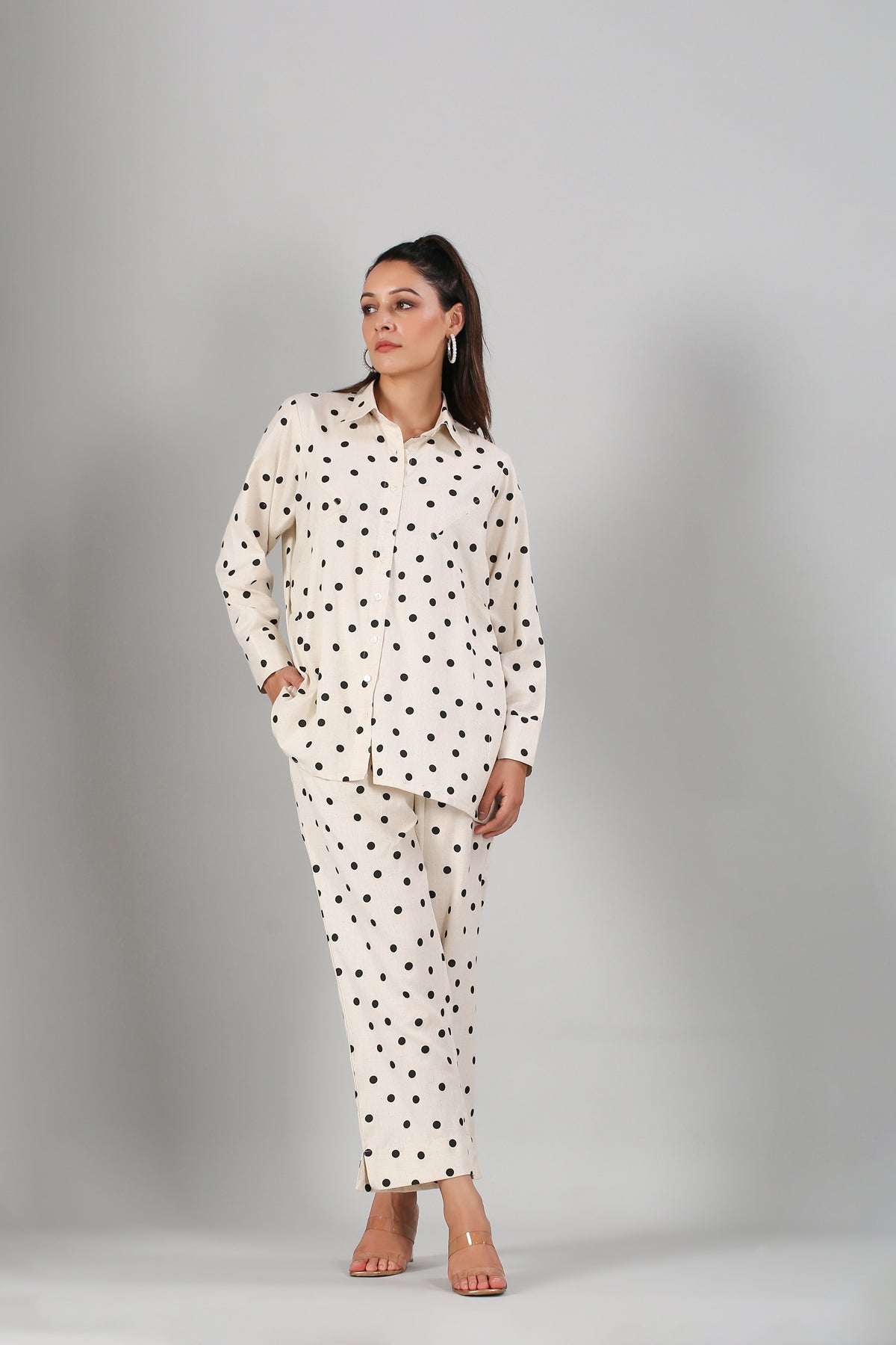 Model wearing Stylera two piece outfit polka dots cream button up shirt and matching straight leg pants with pockets