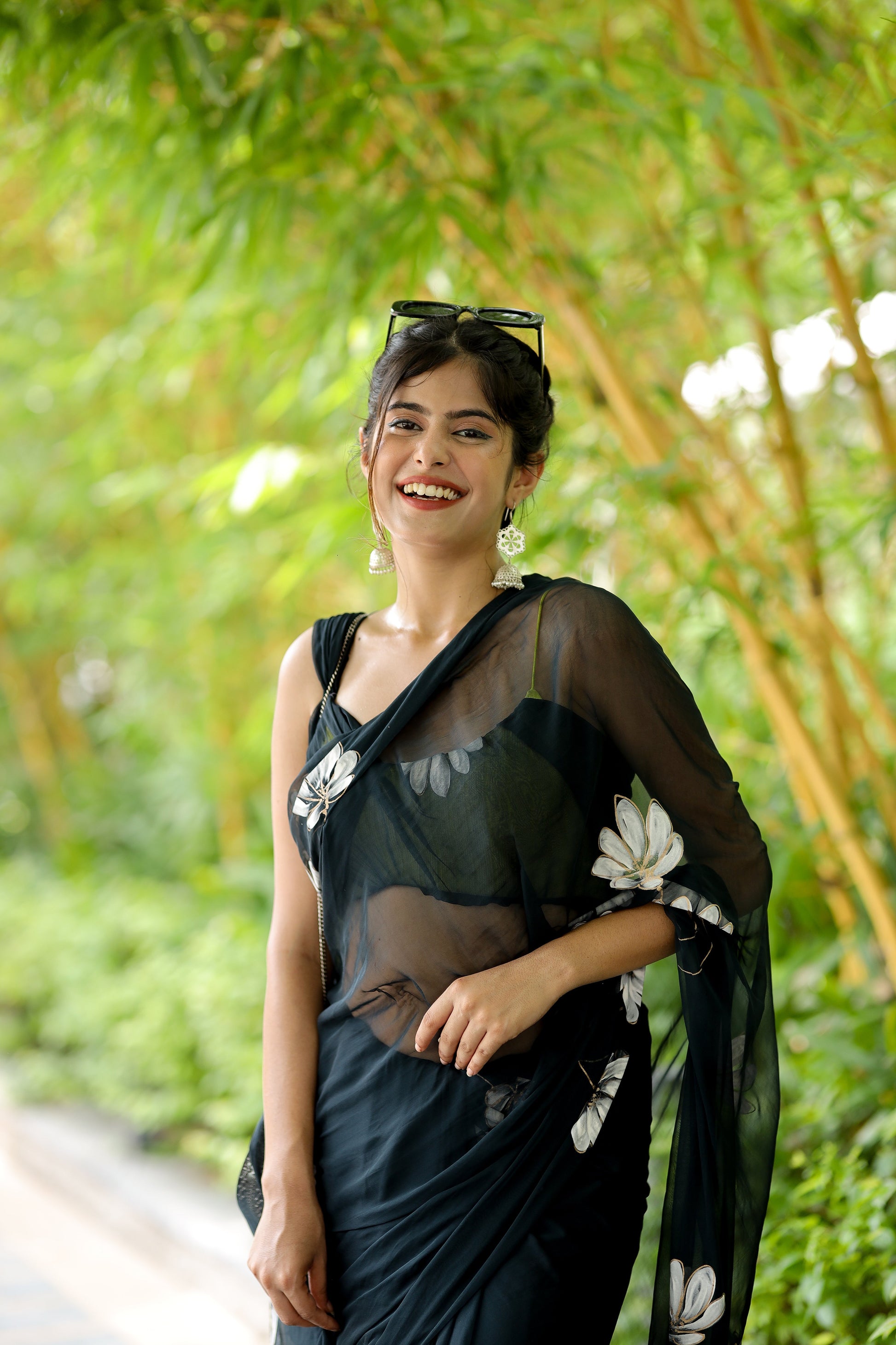 Elegant model wearing a unique black saree for party wear with floral design and stylish accessories