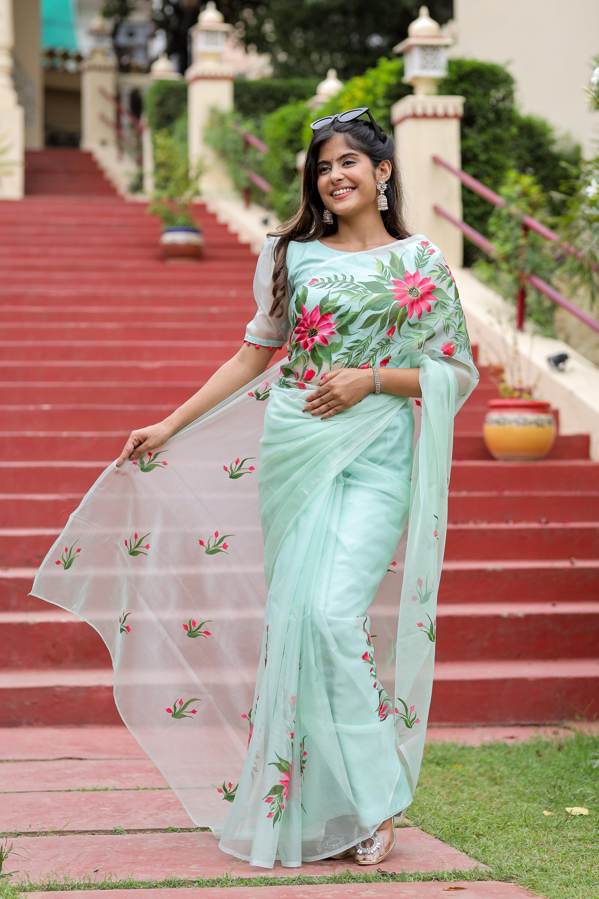 Model wearing a unique designer organza saree with floral embroidery in soft mint green color