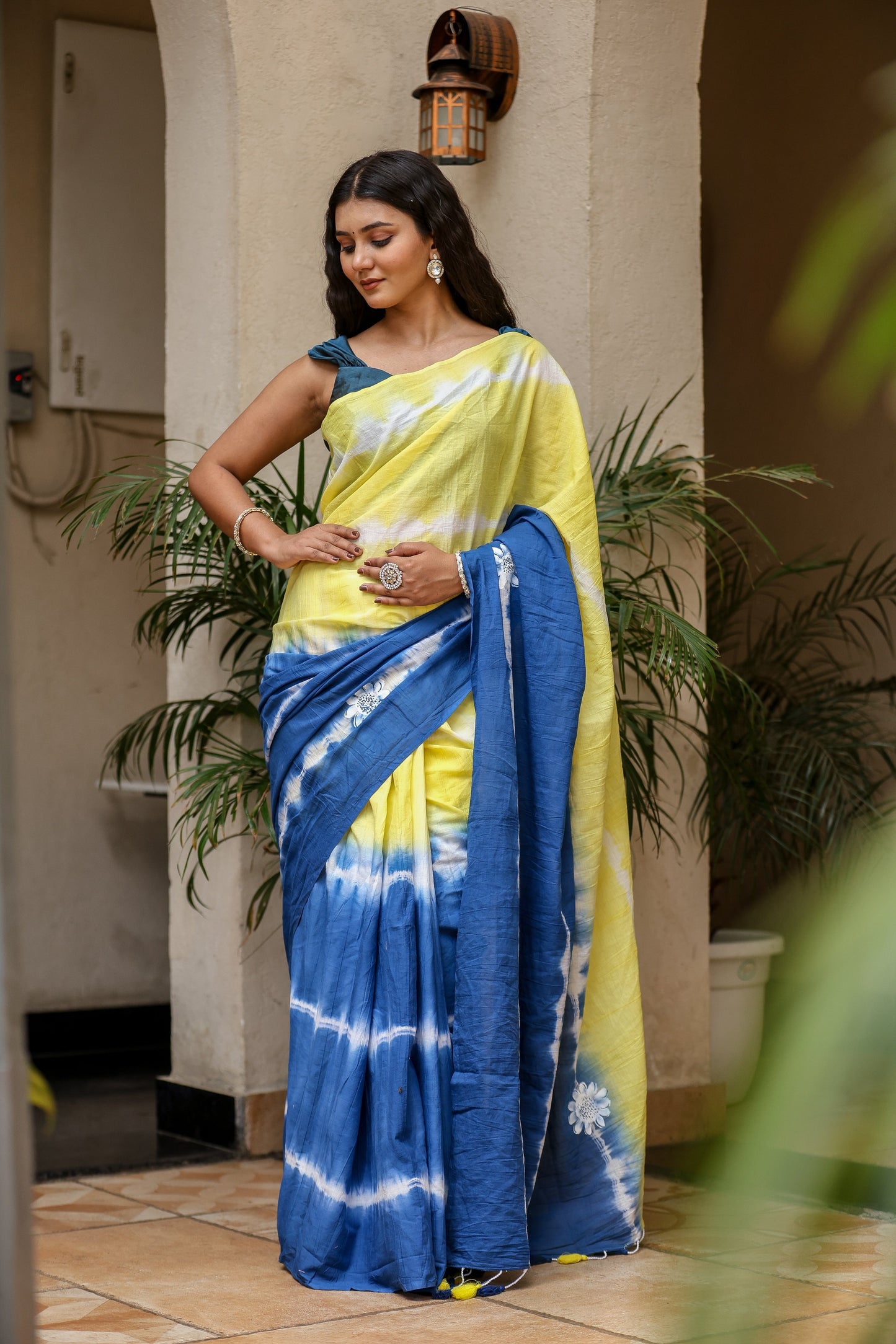 Model wearing a unique designer saree for women in blue and yellow with intricate tie-dye patterns