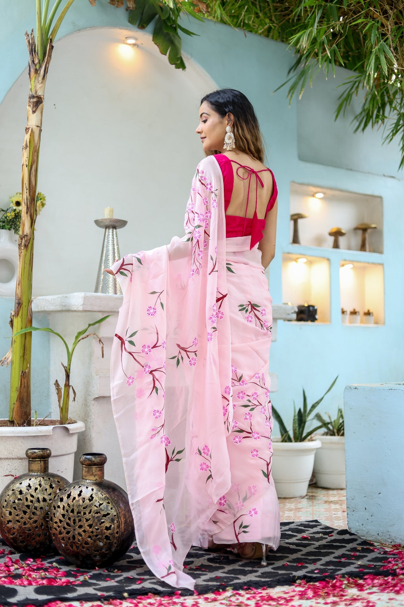 Beautiful unique handpainted saree for weddings with floral designs, worn elegantly outdoors.