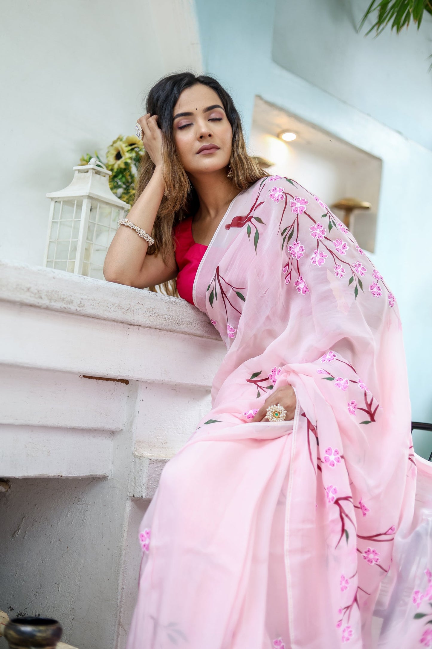 Elegant woman wearing a unique handpainted saree for weddings with floral embroidery in soft pink