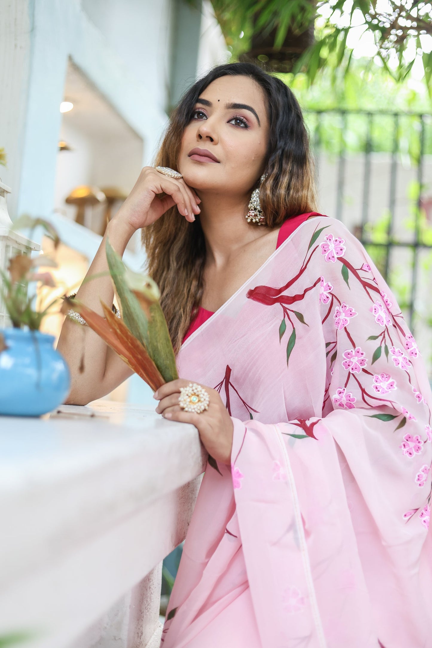 Elegant woman wearing a unique handpainted saree for weddings with floral designs in pink hues