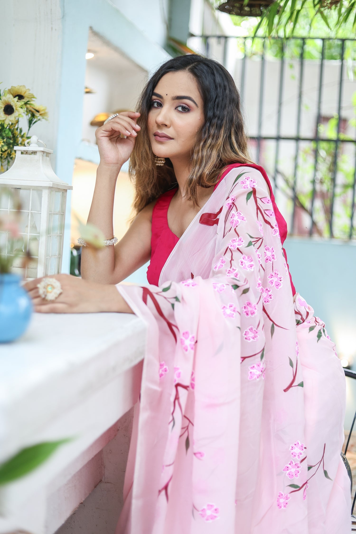 Elegant woman in a pink unique handpainted saree for weddings with floral designs draped gracefully