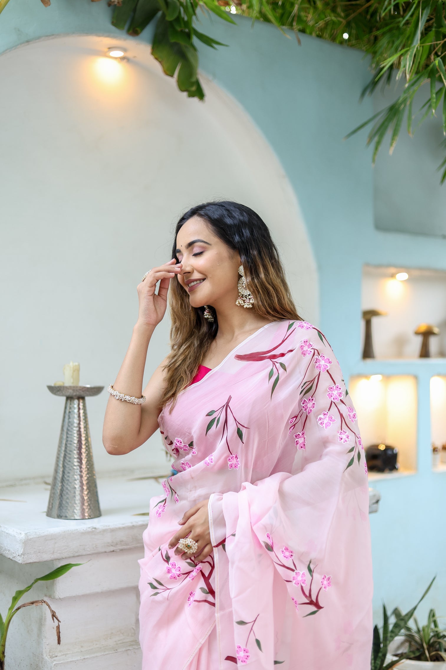 Elegant woman wearing a unique handpainted saree for weddings, adorned with floral embroidery.
