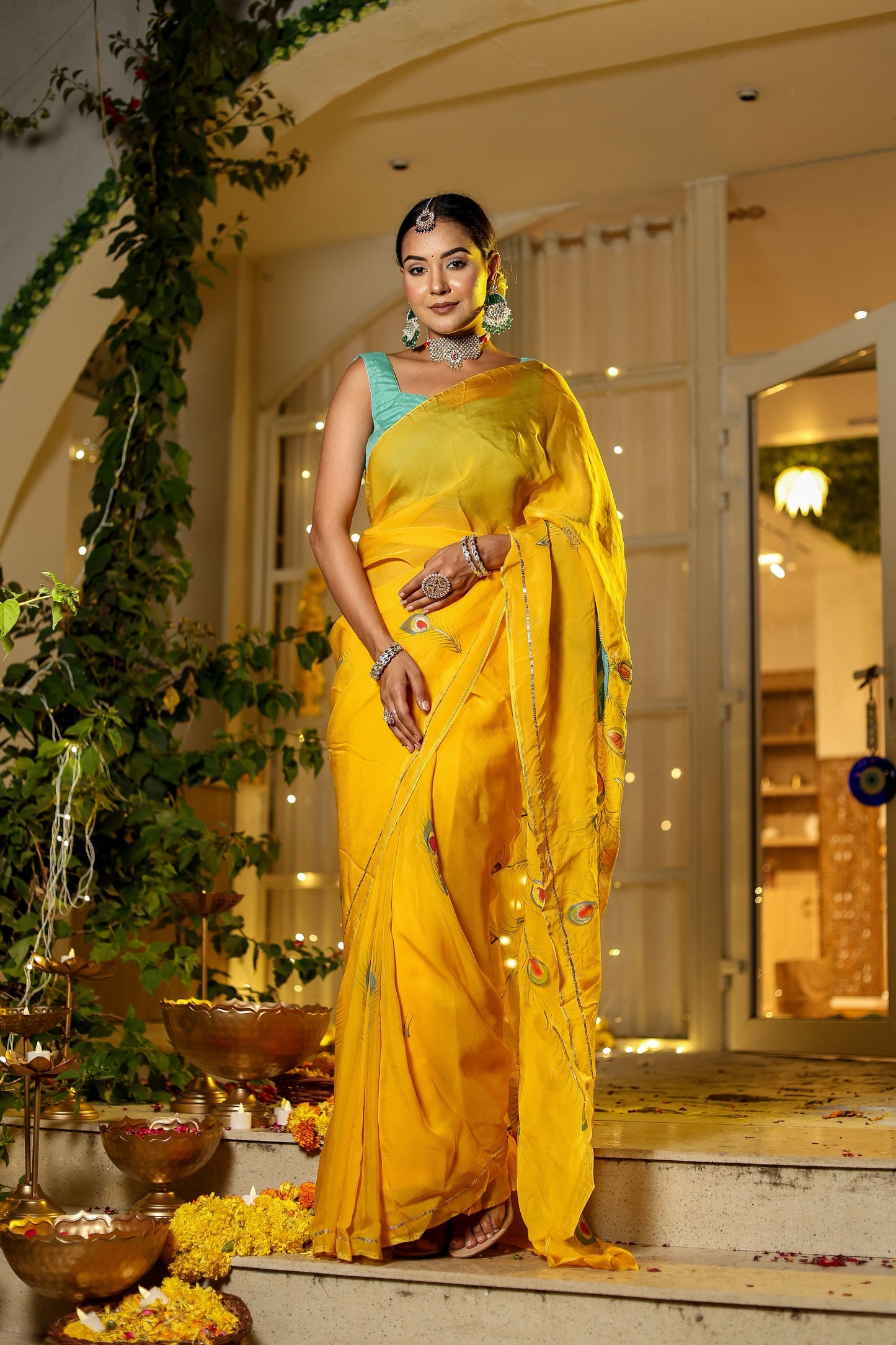 A woman wearing a unique Indian saree with embroidery in vibrant yellow, displayed elegantly at a festive setting