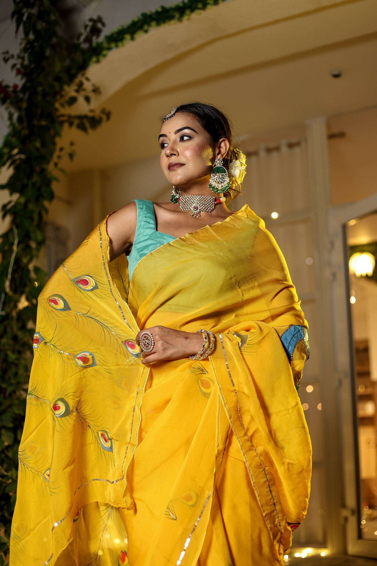Elegant woman in yellow wearing a unique Indian saree with embroidery, showcasing vibrant peacock designs