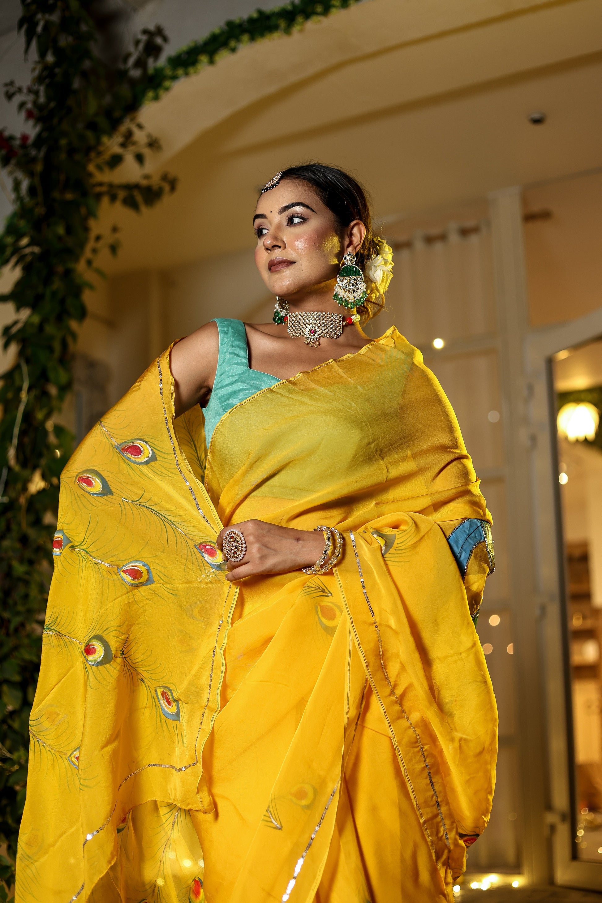 Elegant woman in yellow wearing a unique Indian saree with embroidery, showcasing vibrant peacock designs