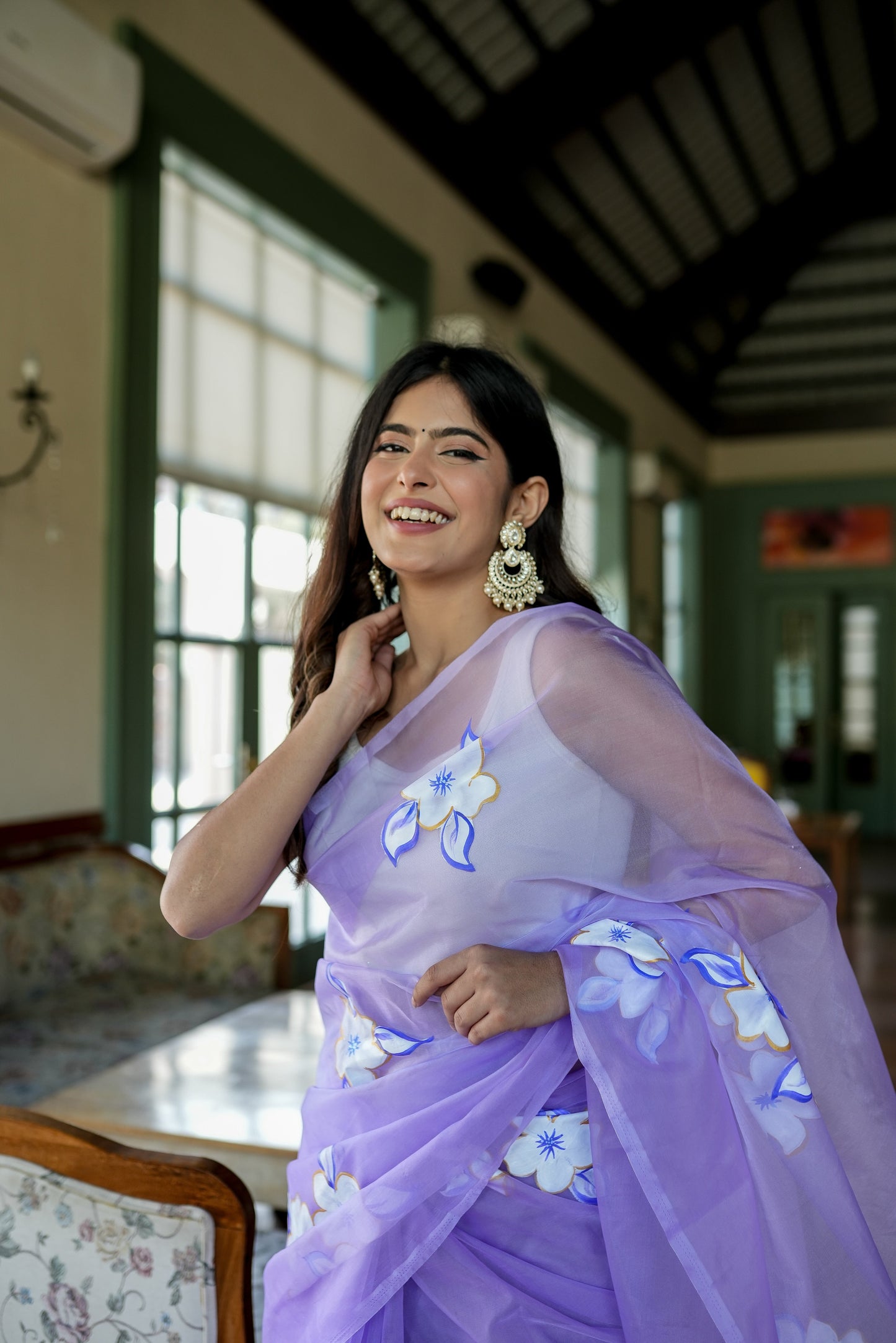 Model wearing a unique organza saree with artwork in lavender, showcasing intricate floral designs.