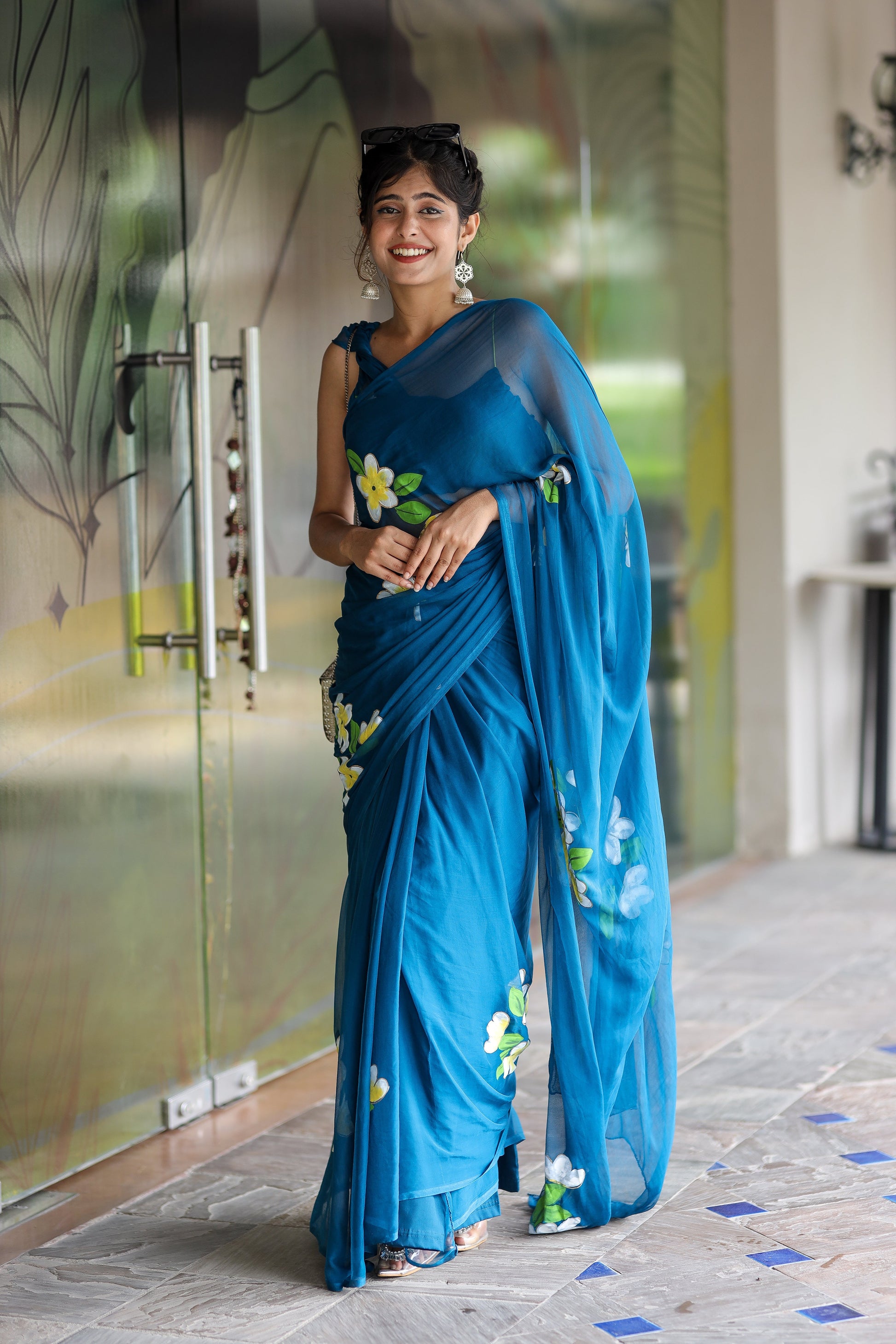 Model wearing a unique party wear saree in blue with floral embroidery, perfect for festive occasions