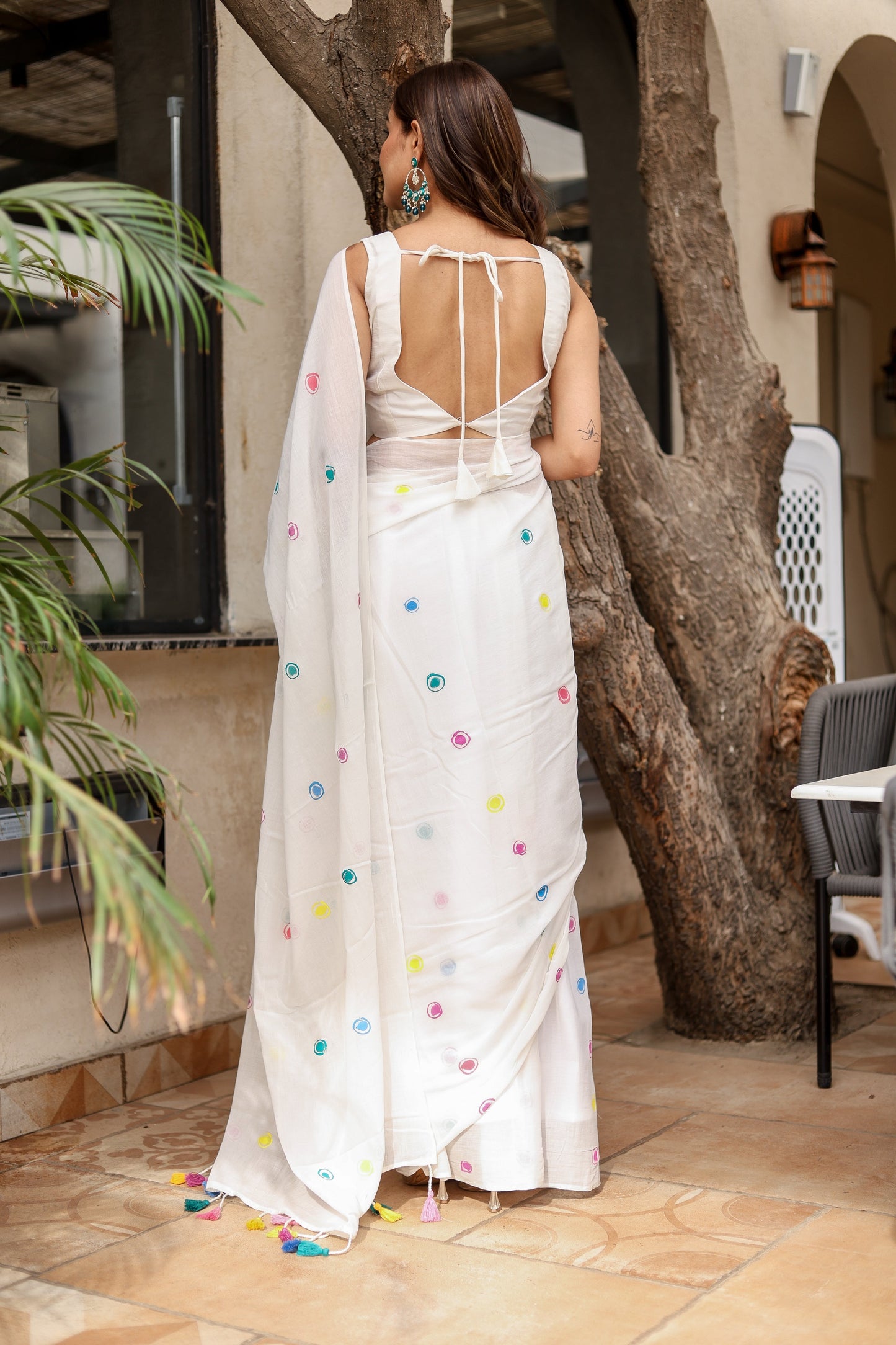 Elegant white cotton saree with tassels featuring colorful accents, perfect for casual or festive occasions