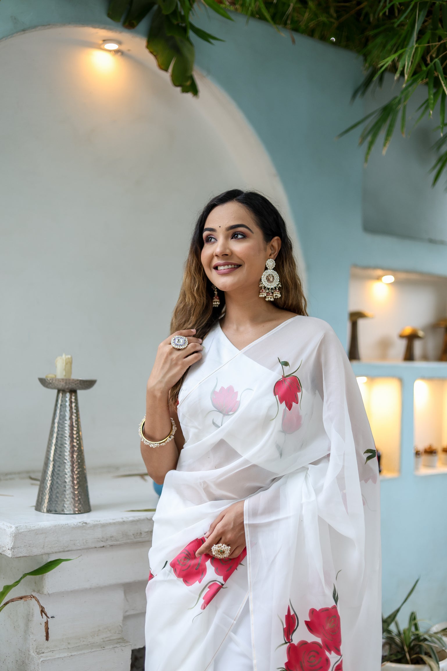 Elegant white organza saree for women with floral patterns, styled with traditional accessories