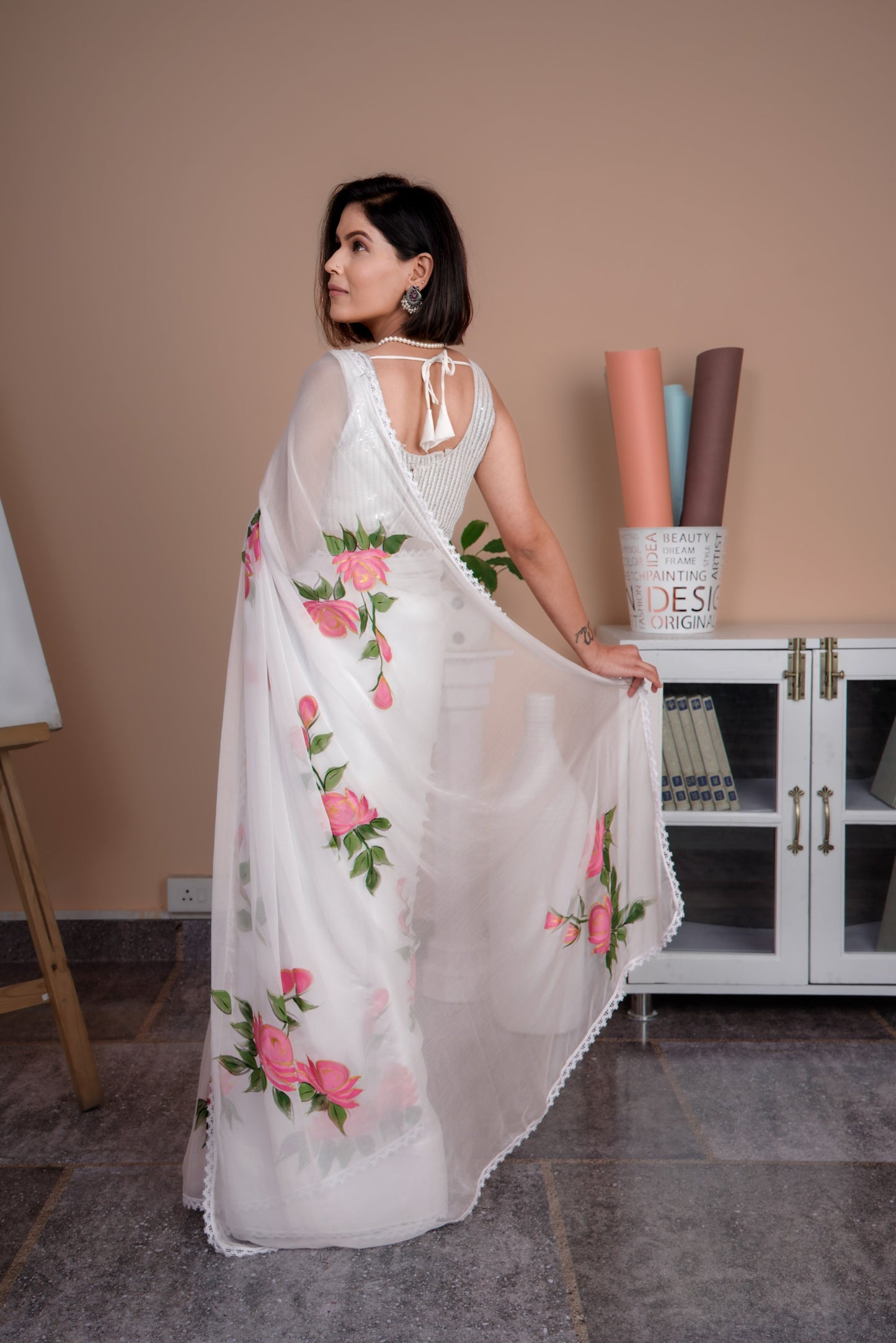 Elegant white saree with pink floral print draped gracefully, showcasing delicate flower designs