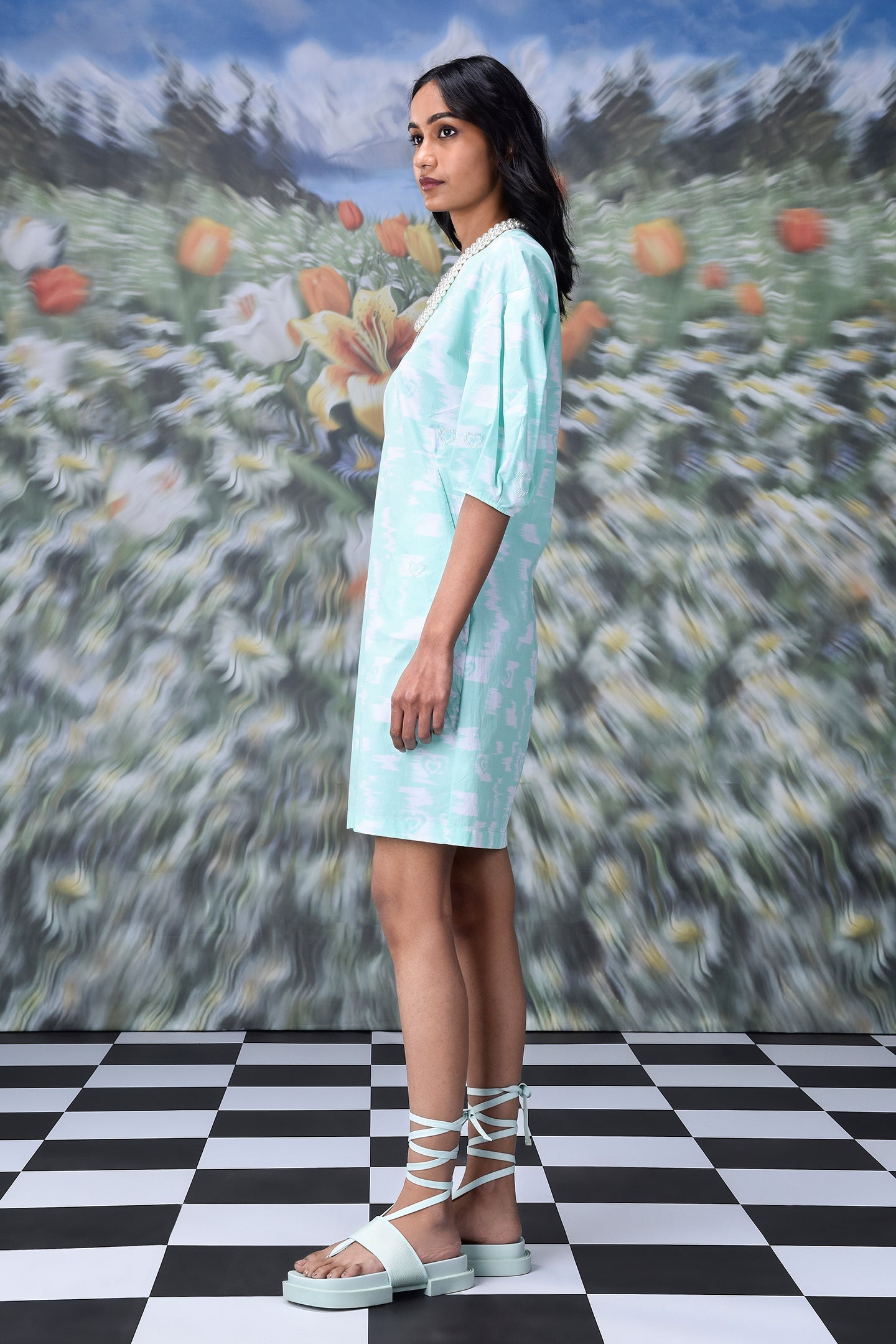 Model wearing Stylera women's ikkat check casual dress in mint knee length side profile with lace up sandals