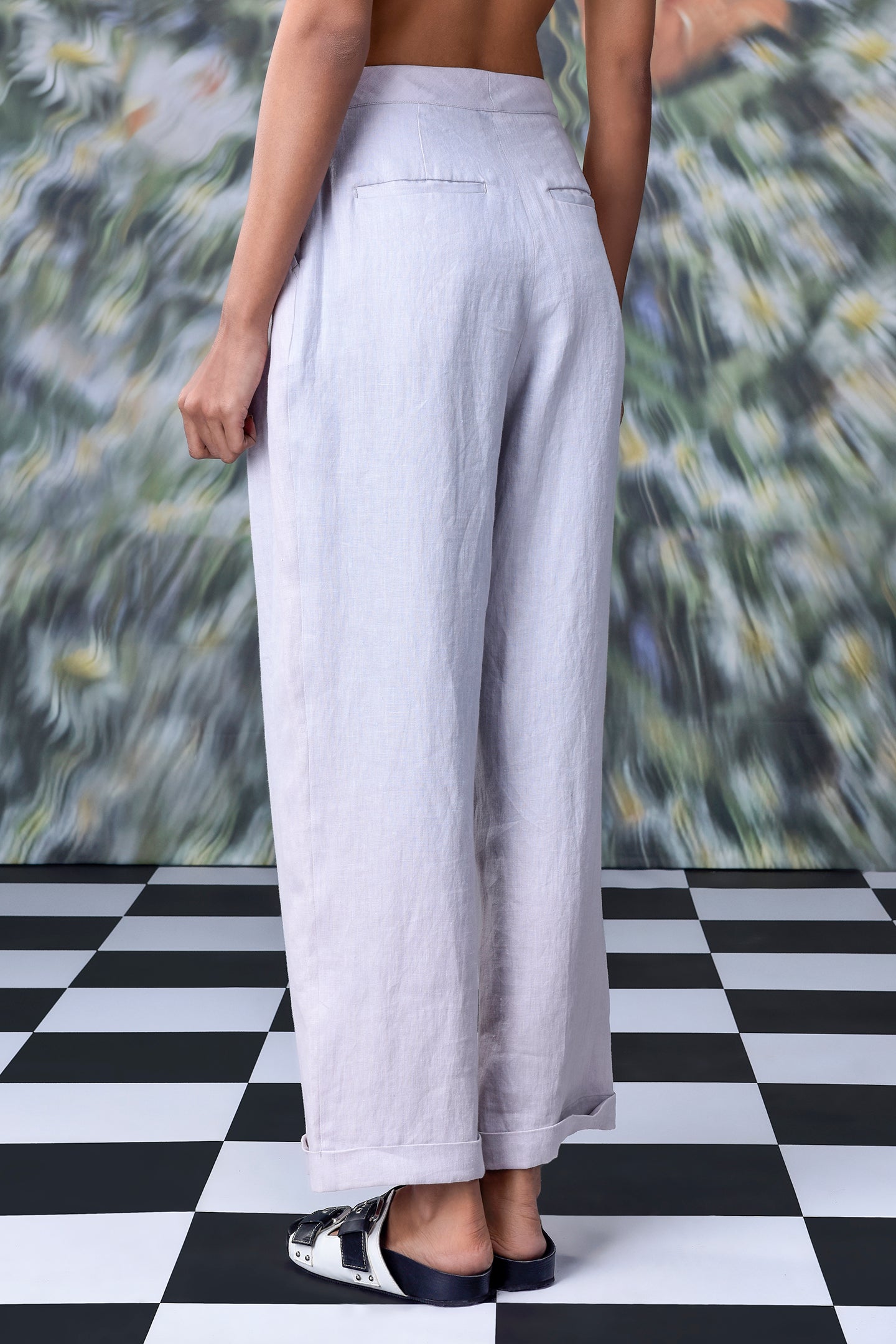 Back view of women's regular fit linen pants by Stylera in light fabric on a model