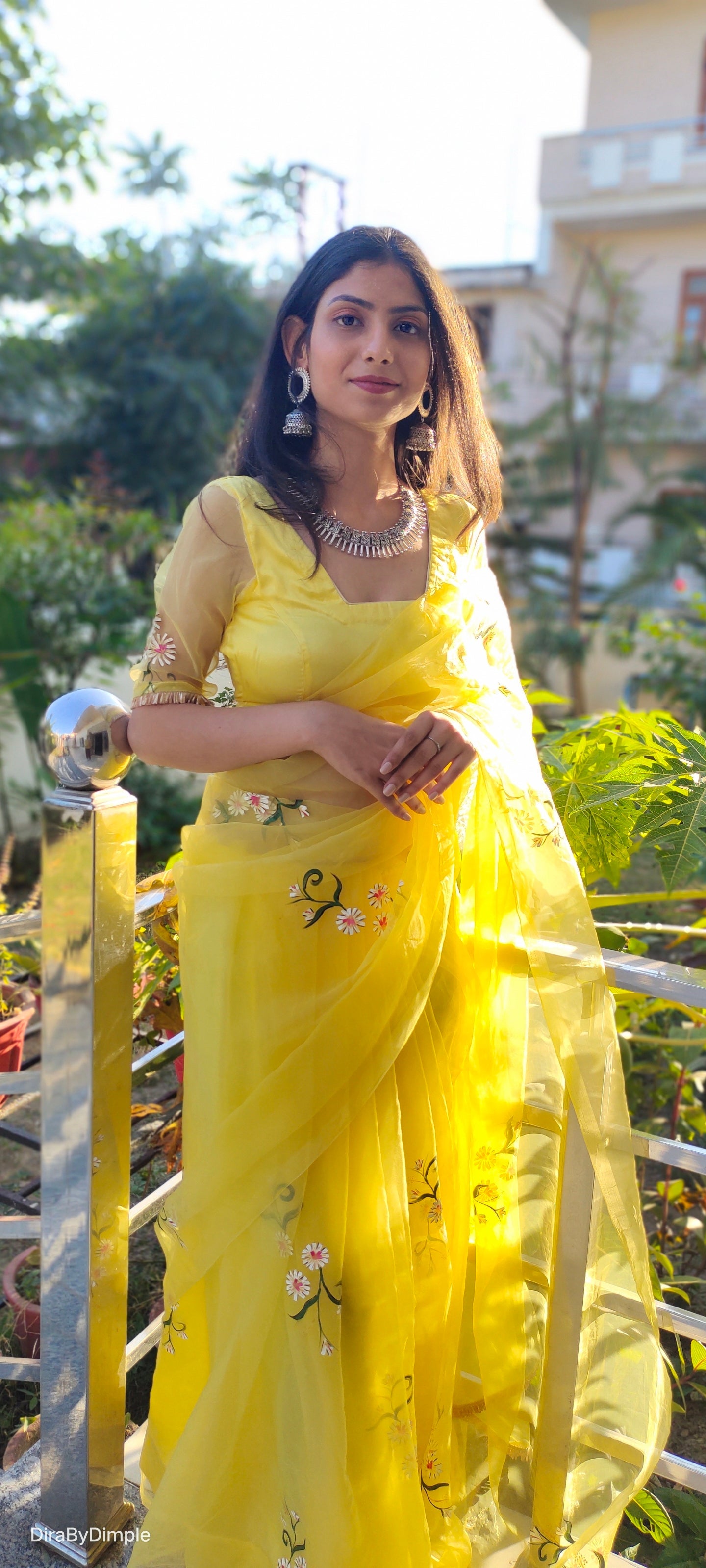 Model wearing a yellow sunflower saree with floral embroidery and elegant accessories
